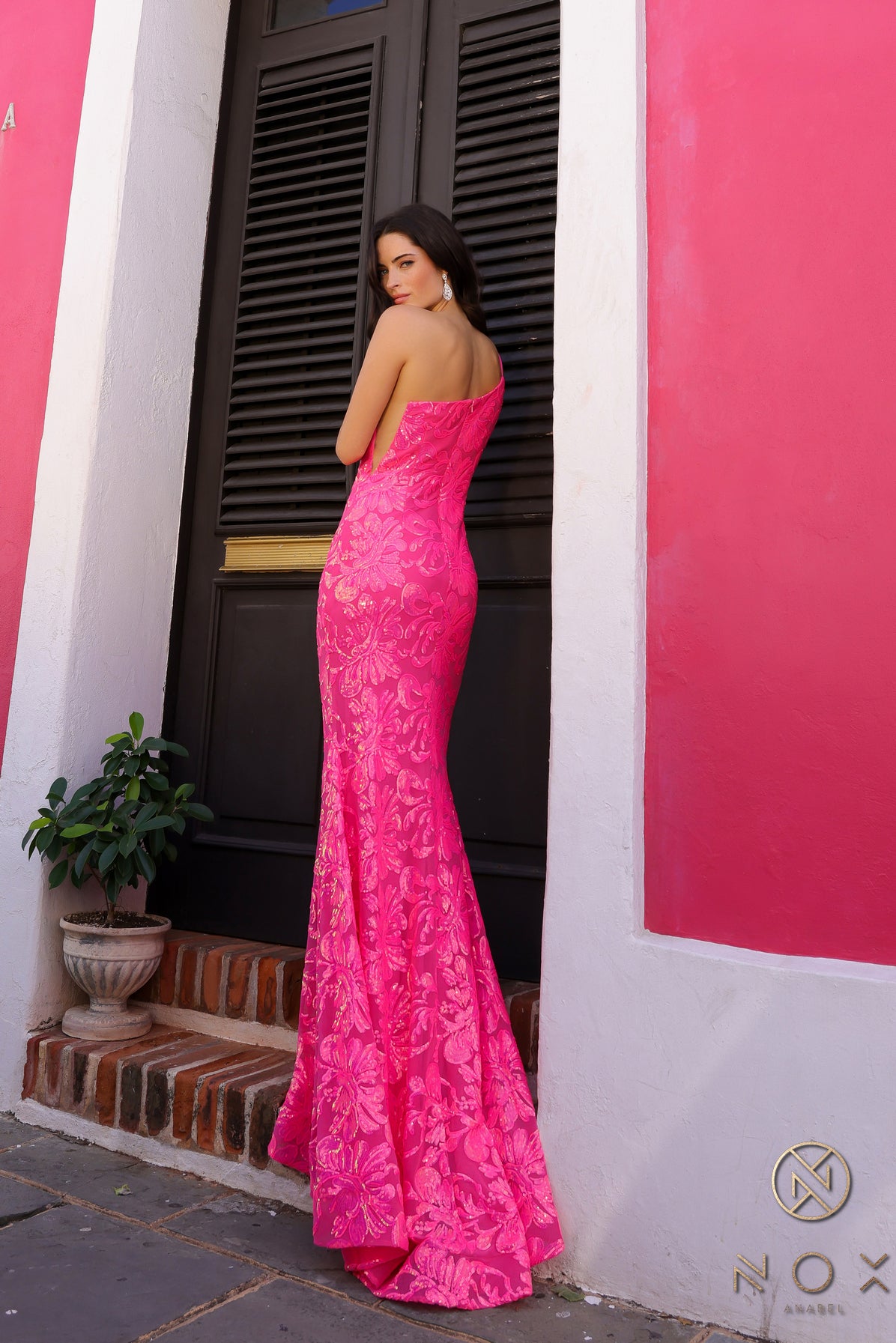 Be the ultimate showstopper in this stunning Nox Anabel R1308 sequin lace one shoulder prom dress. The mermaid silhouette and formal design will give you the confidence to shine on any pageant stage. Guaranteed to make a lasting impression, this gown is a must-have for any special occasion.  Size: 0-16  Colors: Fuchsia, Aqua Blue, White Multi