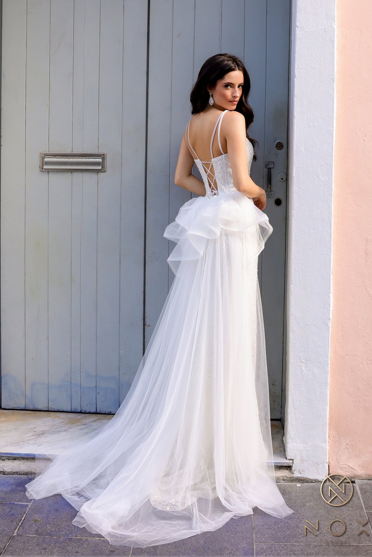 Elevate your look with the Nox Anabel Y1475 Long Beaded Prom Dress. The ruffle top and corset detailing create a flattering silhouette while the beaded overskirt adds a touch of glamour. Perfect for formal events and pageants, this gown is sure to impress.

Sizes: 4-16

Colors: Lilac, White