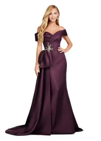 This Ashley Lauren 11425 Long Prom Dress is the perfect choice for any formal occasion. The off-shoulder design adds a touch of elegance, while the fitted satin fabric hugs your figure for a flattering silhouette. The overskirt adds a dramatic flare, making you feel like a pageant queen. Elevate your style with this versatile and stunning dress. An elegant off the shoulder neckline drapes the shoulders in elegant evening gown. The look is complete with beaded details and a side overskirt.