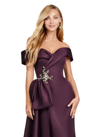 This Ashley Lauren 11425 Long Prom Dress is the perfect choice for any formal occasion. The off-shoulder design adds a touch of elegance, while the fitted satin fabric hugs your figure for a flattering silhouette. The overskirt adds a dramatic flare, making you feel like a pageant queen. Elevate your style with this versatile and stunning dress. An elegant off the shoulder neckline drapes the shoulders in elegant evening gown. The look is complete with beaded details and a side overskirt.