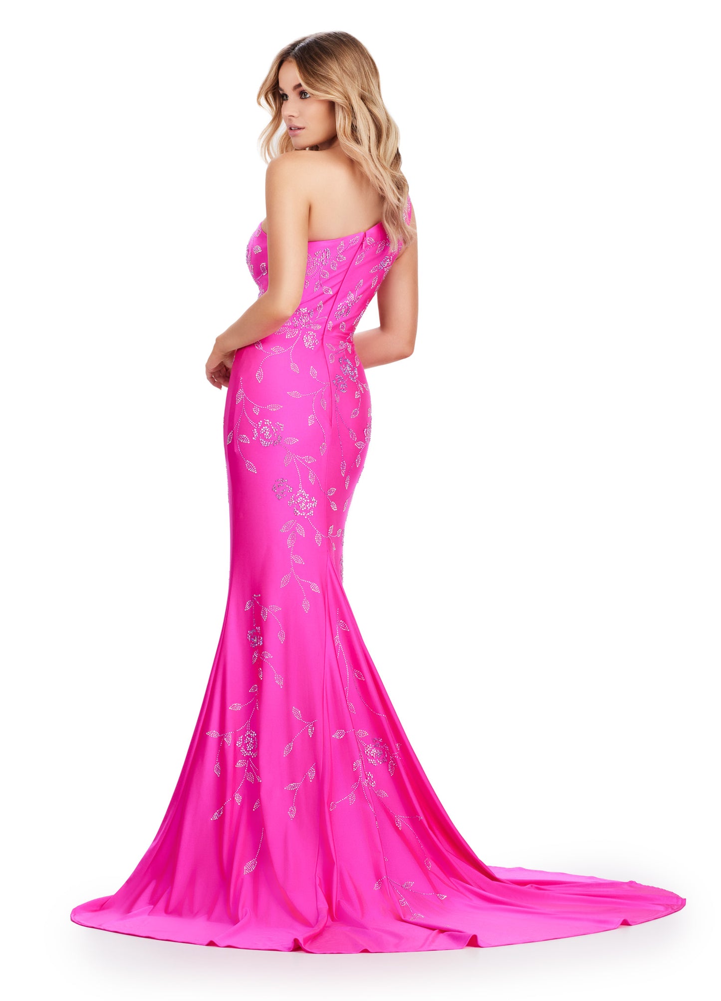 Make a stunning entrance in the Ashely Lauren 11525 Long Prom Dress. Featuring a one shoulder design and a press on floral bead pattern, this gown exudes sophistication and elegance. The jersey fabric offers a comfortable and flattering fit, perfect for any formal occasion. Make a statement in this pageant-worthy gown. This one shoulder jersey gown features a delicate multi-colored heat set stone floral bead pattern that cascades down onto the skirt.