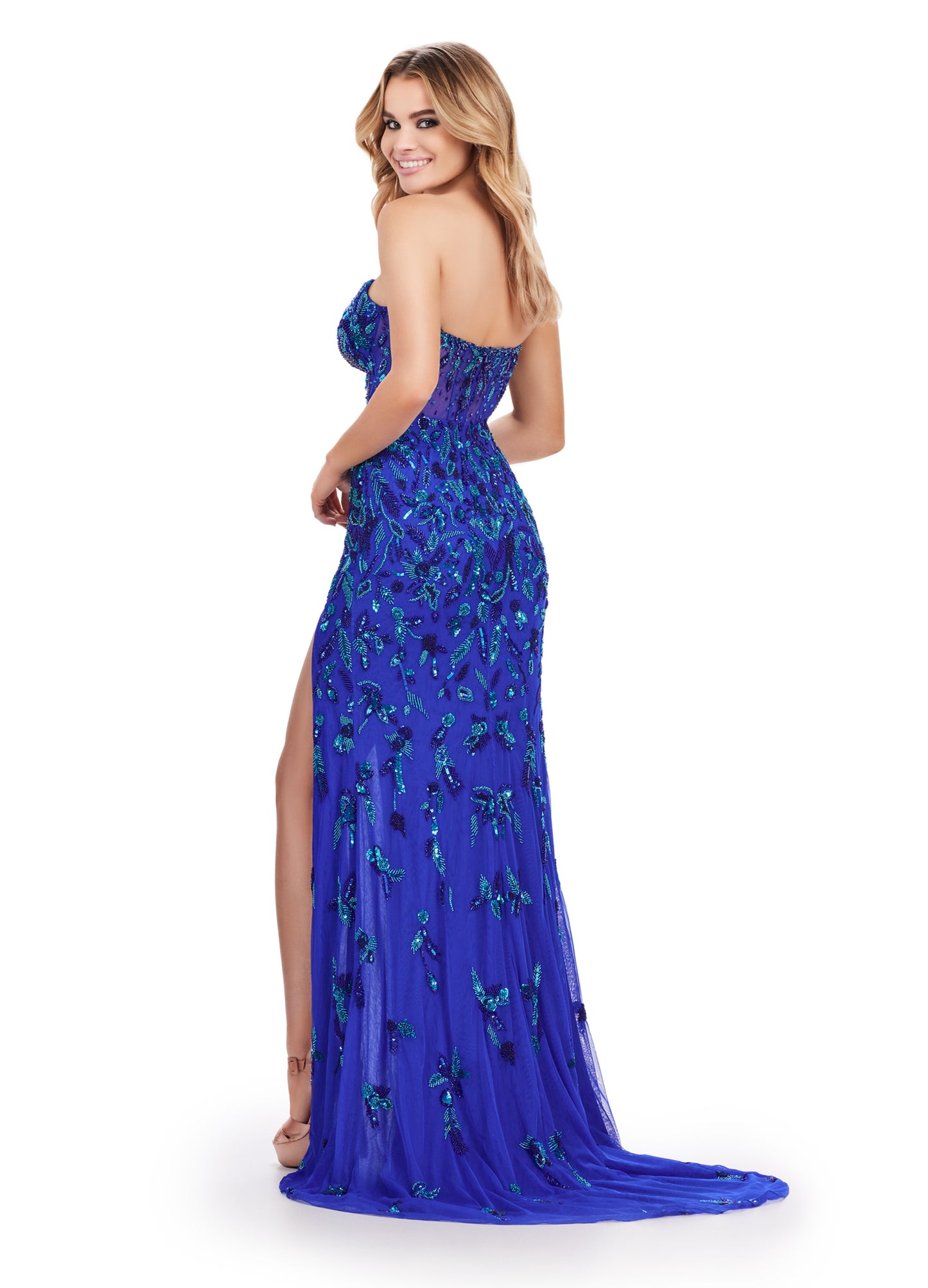 Achieve a stunning look with Ashley Lauren's 11614 Long Prom Dress. The beaded strapless gown features a corset bustier and a slit, adding a touch of elegance to its formal pageant style. Confidently stand out and make a statement at your special occasion. Feel like royalty in this elegant gown. This fully beaded design features an illusion corset bustier. The beading flows throughout the gown, which has a left leg slit.