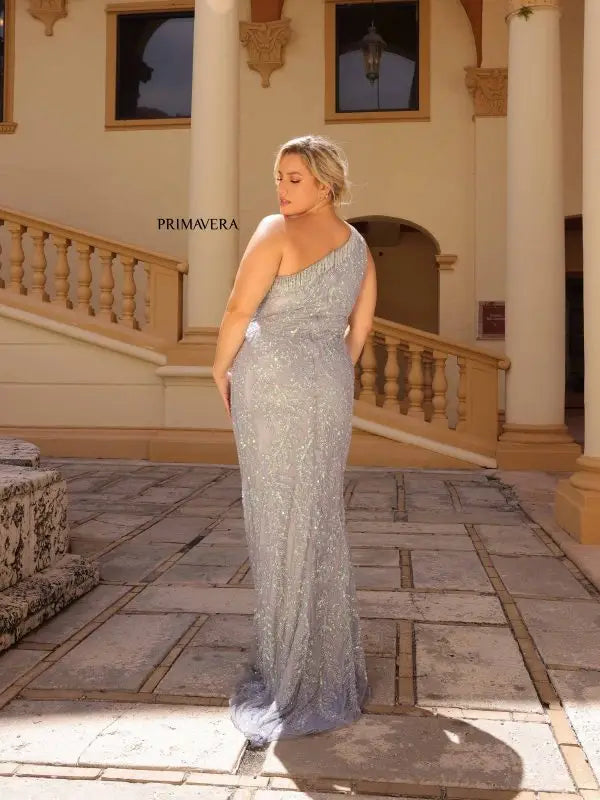 Make a statement in Primavera Couture's 14047 Plus Size Sequin Prom Dress. Designed to hug your curves, this dress features an asymmetrical one shoulder neckline, Sequins, beading and fringe detail. For a glamorous look, pair it with strappy heels and a small clutch.  Sizes: 14W-24W  Colors: Black, Fuchsia, Platinum 