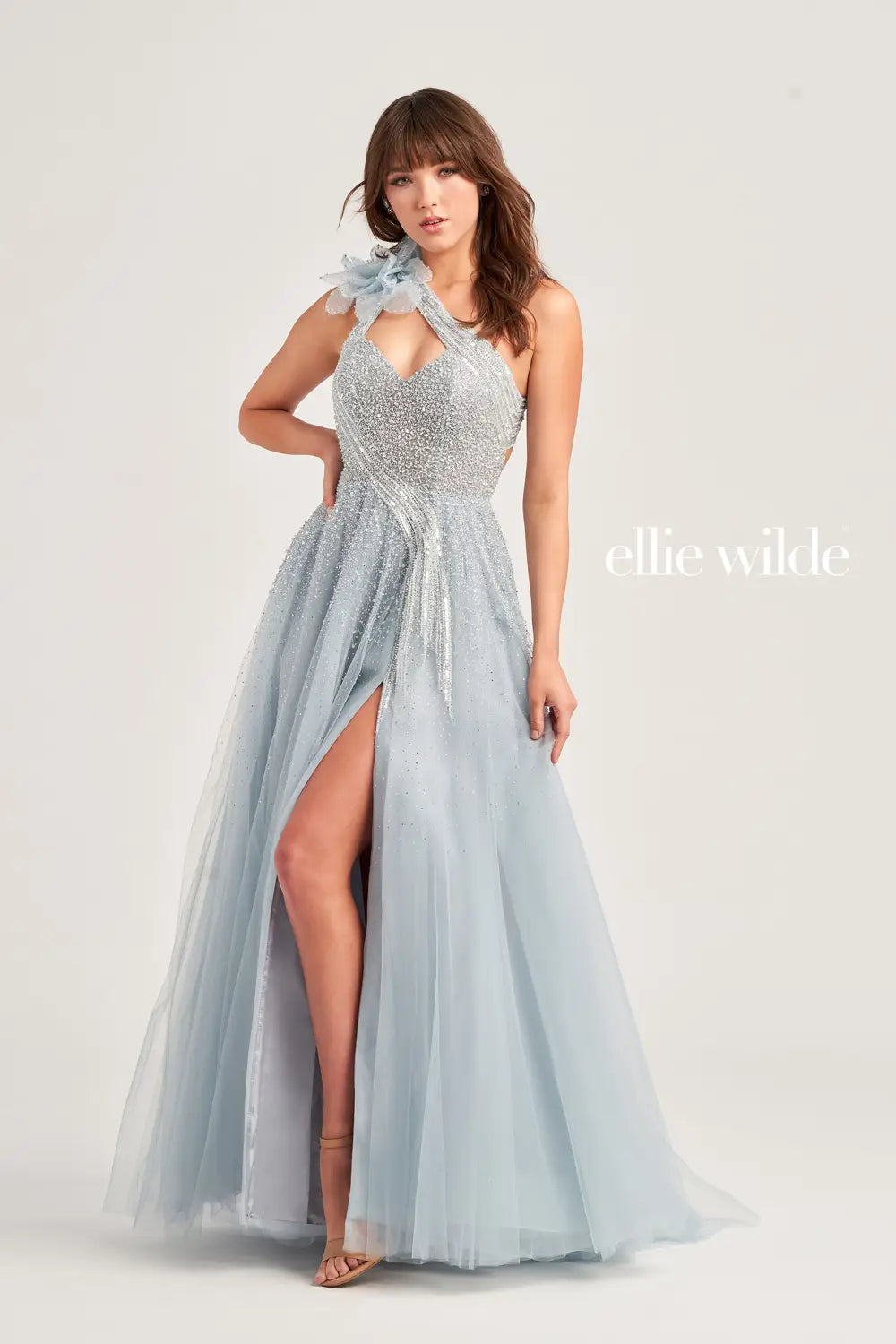 The Ellie Wilde EW35086 Dress boasts a stunning one shoulder cut out design adorned with intricate beading and a bow detail. Its ballgown silhouette, paired with a maxi slit, creates a dramatic and elegant look. Perfect for formal events, this dress is sure to make a lasting impression.  Sizes: 00-16  Colors: Misty Blue, Black/Gunmetal