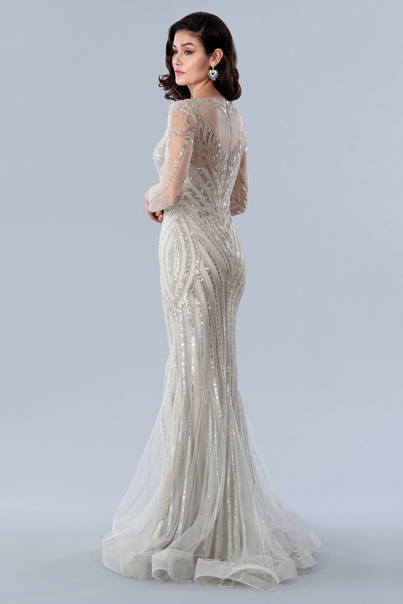 This luxurious Stella Couture 23369 gown is the perfect choice for black-tie occasions. Boasting a fully beaded and sequin-embellished sheer construction, it features beautiful long sleeves and a high neckline, perfect for making a dazzling entrance. Crafted with a mermaid shape, it's sure to flatter the figure.  Sizes: 6-20  Colors: Silver