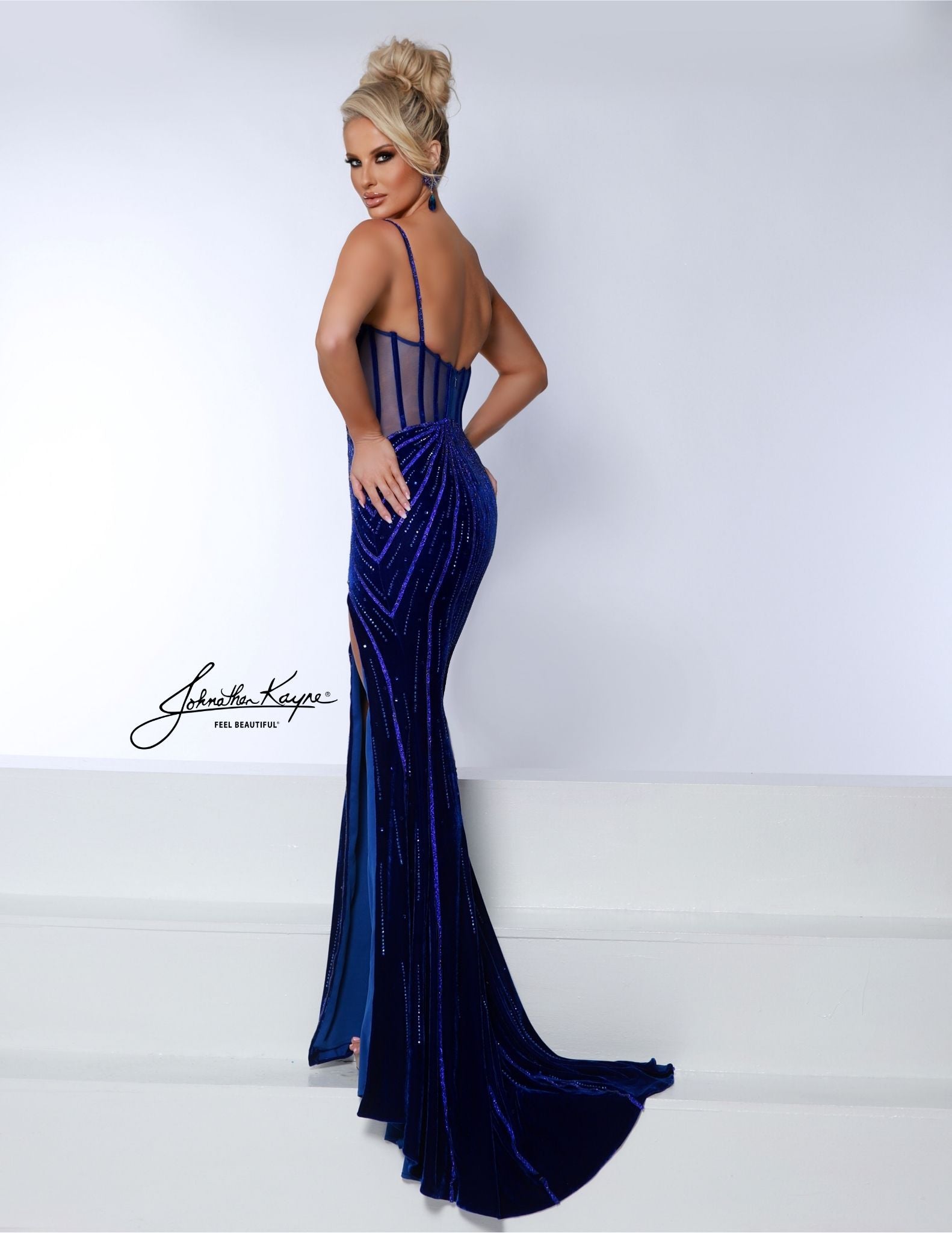 Experience elegance and luxury with the Johnathan Kayne 3065 Long Velvet Sheer Prom Dress. This stunning dress features a velvet corset and a crystal slit v-neck, perfect for making a statement. With sheer accents and a long silhouette, this dress will make you feel like a true Hollywood star on your special night. Speechless. This stretch velvet wonder features a classic neckline, fit and flare magic, and sass with every step thanks to its leg slit. With boning and beading that shimmer, it’s your ultimate 