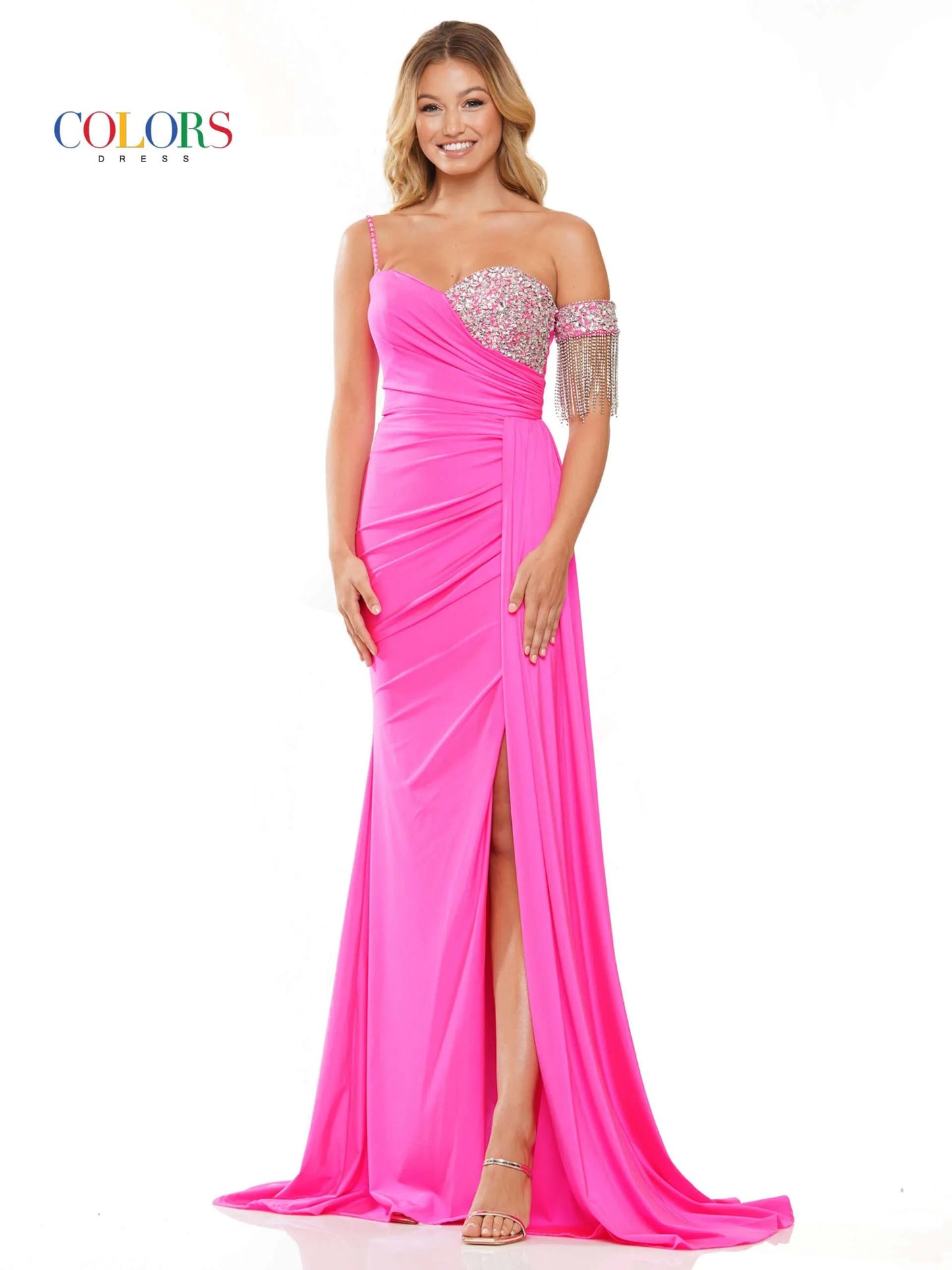 Step onto the red carpet in style with the Colors Dress 3275 Fitted Ruched Slit Overskirt Prom Dress. The one side off the shoulder design is embellished with eye-catching crystal details, while the fitted silhouette is accentuated with a ruched overskirt and fringe detailing. Be the standout at any pageant or prom with this beautiful and glamorous dress.  Sizes: 0-22  Colors: Black, Royal, Deep Green, Hot Pink