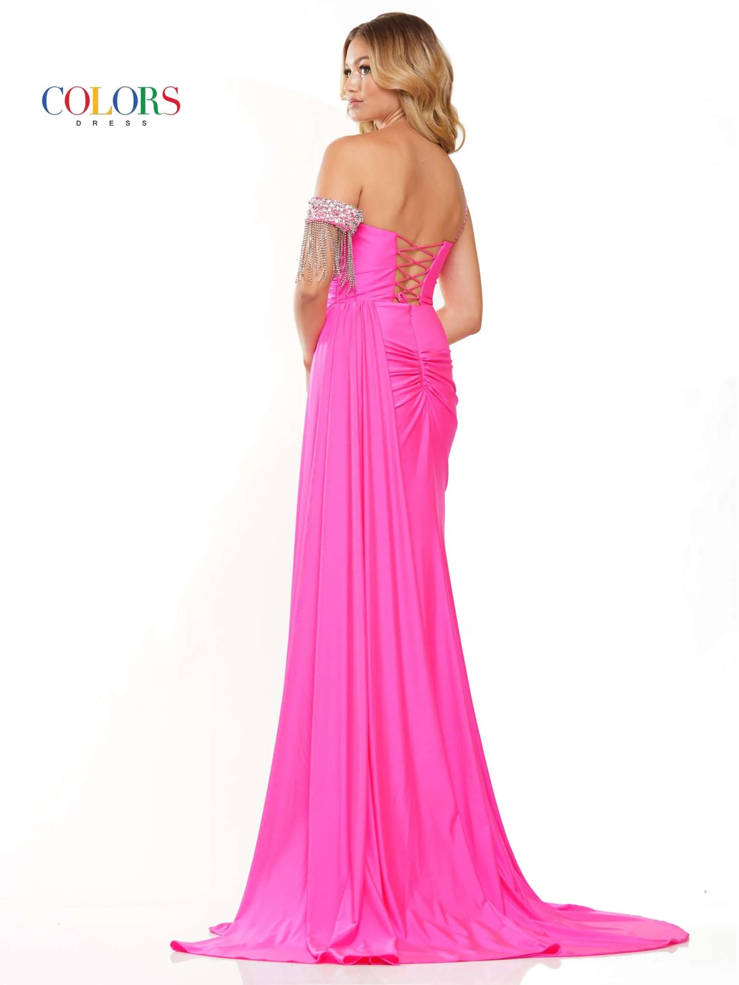 Step onto the red carpet in style with the Colors Dress 3275 Fitted Ruched Slit Overskirt Prom Dress. The one side off the shoulder design is embellished with eye-catching crystal details, while the fitted silhouette is accentuated with a ruched overskirt and fringe detailing. Be the standout at any pageant or prom with this beautiful and glamorous dress.  Sizes: 0-22  Colors: Black, Royal, Deep Green, Hot Pink