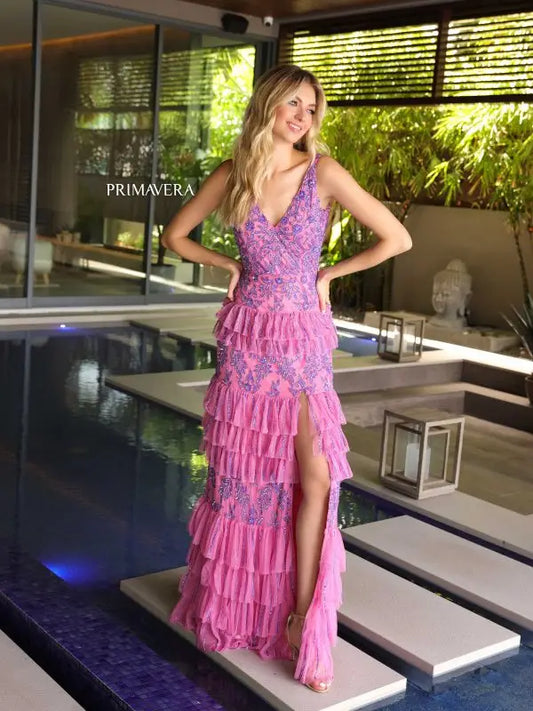 Elevate your formal look with the Primavera Couture 4106 Long Prom Dress. This stunning gown features an intricate sequin and beaded design, cascading layered ruffles, and a high slit for a touch of glamour. The fitted silhouette is perfect for showing off your figure, making this dress a statement piece for any special occasion.