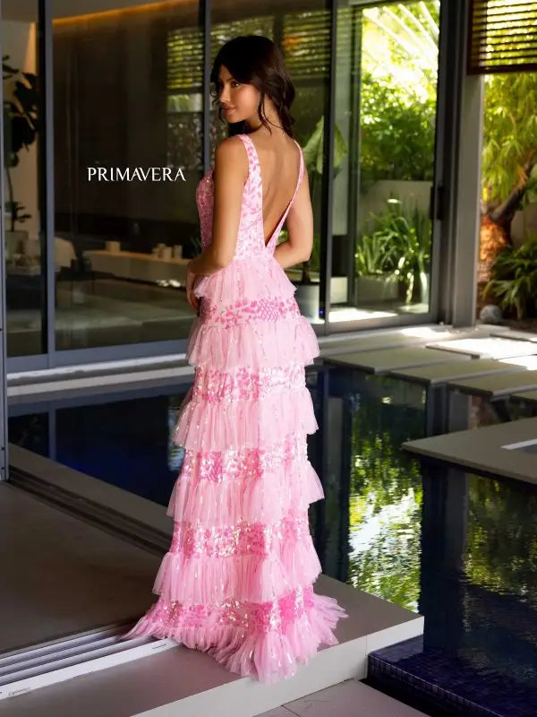 Add a touch of glamour to your special evening with the Primavera Couture 4142 Long Prom Dress. This elegantly sequined gown boasts a fitted silhouette with a high slit and open low back, perfect for showing off your curves. The layered ruffle adds a flirty touch, making it ideal for prom or pageants.