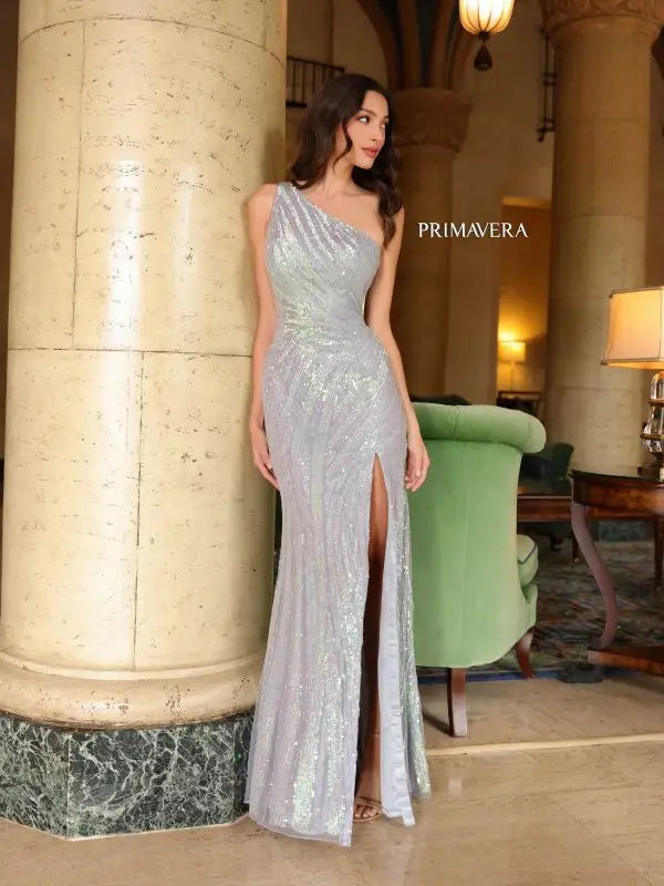 Elevate your formal pageant look with the Primavera Couture 4152 gown. Its lace-up back, high slit, and beaded sequin details create a stunning and fitted silhouette. The asymmetrical design adds a unique touch to this elegant dress. Shine like a star on stage with this beautifully crafted gown.