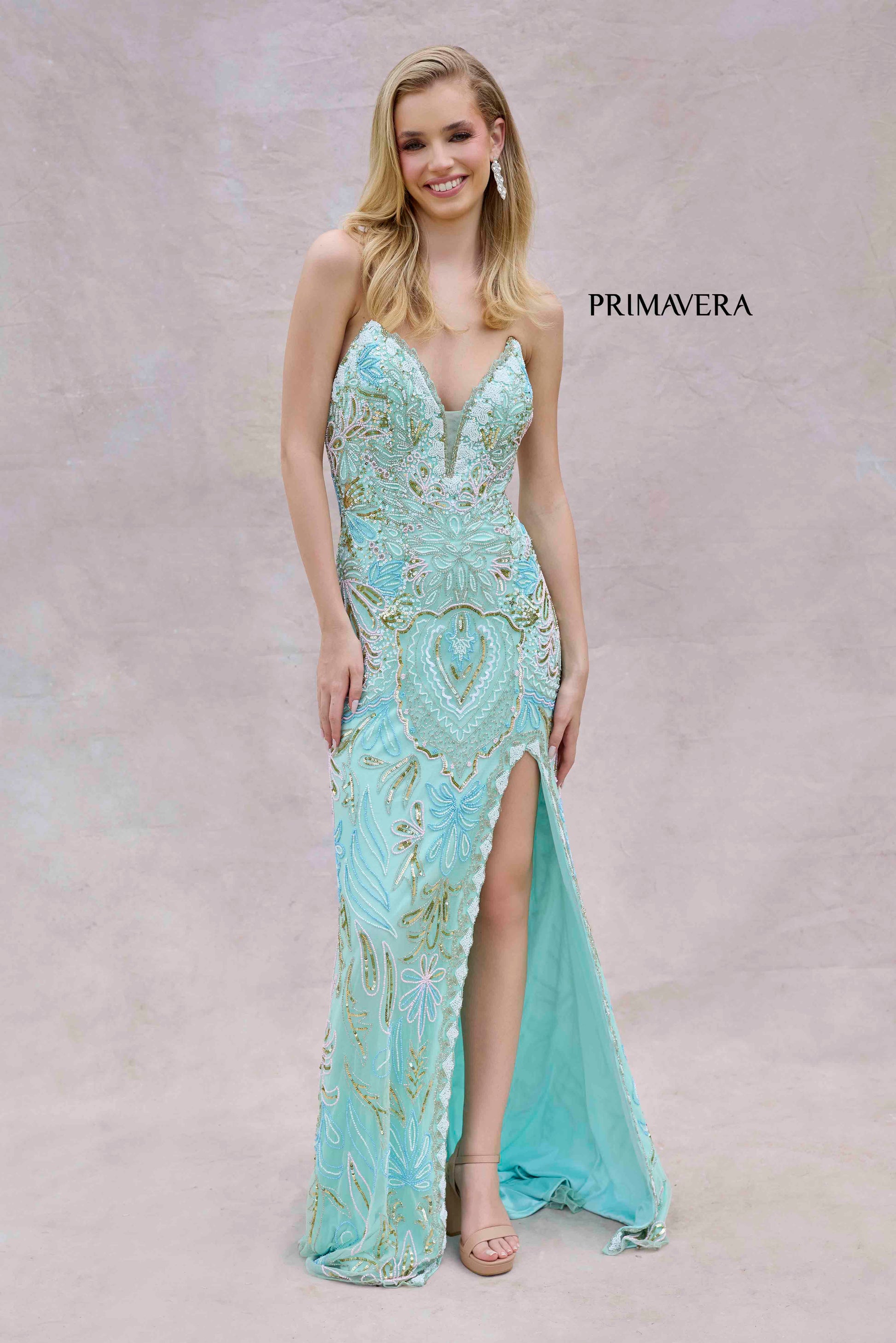 This Primavera Couture 4382 dress exudes elegance with its long beaded strapless corset, slit V-neck design, and formal evening gown style. Perfect for prom or any special occasion, it offers a flattering silhouette and stunning details. Elevate your look with this exquisite dress.