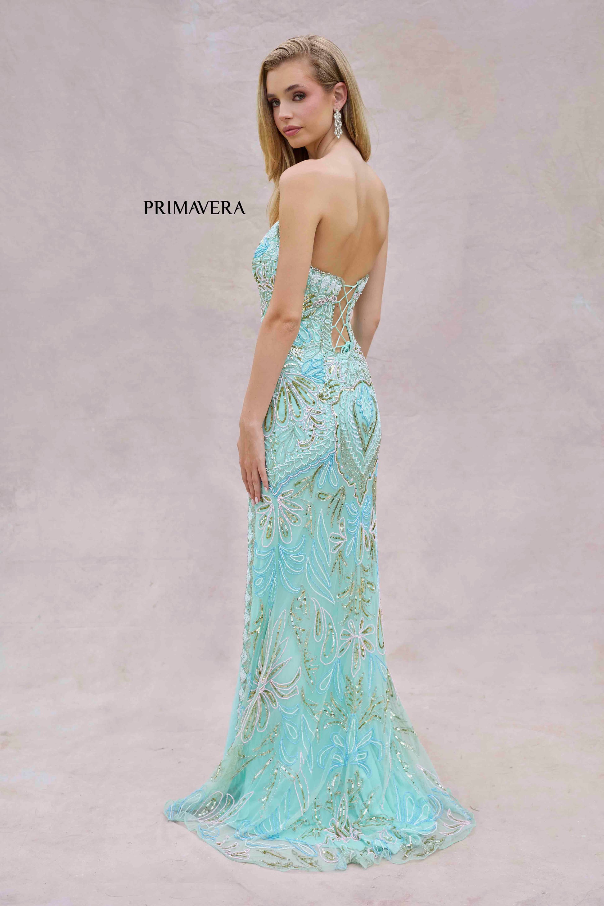 This Primavera Couture 4382 dress exudes elegance with its long beaded strapless corset, slit V-neck design, and formal evening gown style. Perfect for prom or any special occasion, it offers a flattering silhouette and stunning details. Elevate your look with this exquisite dress.