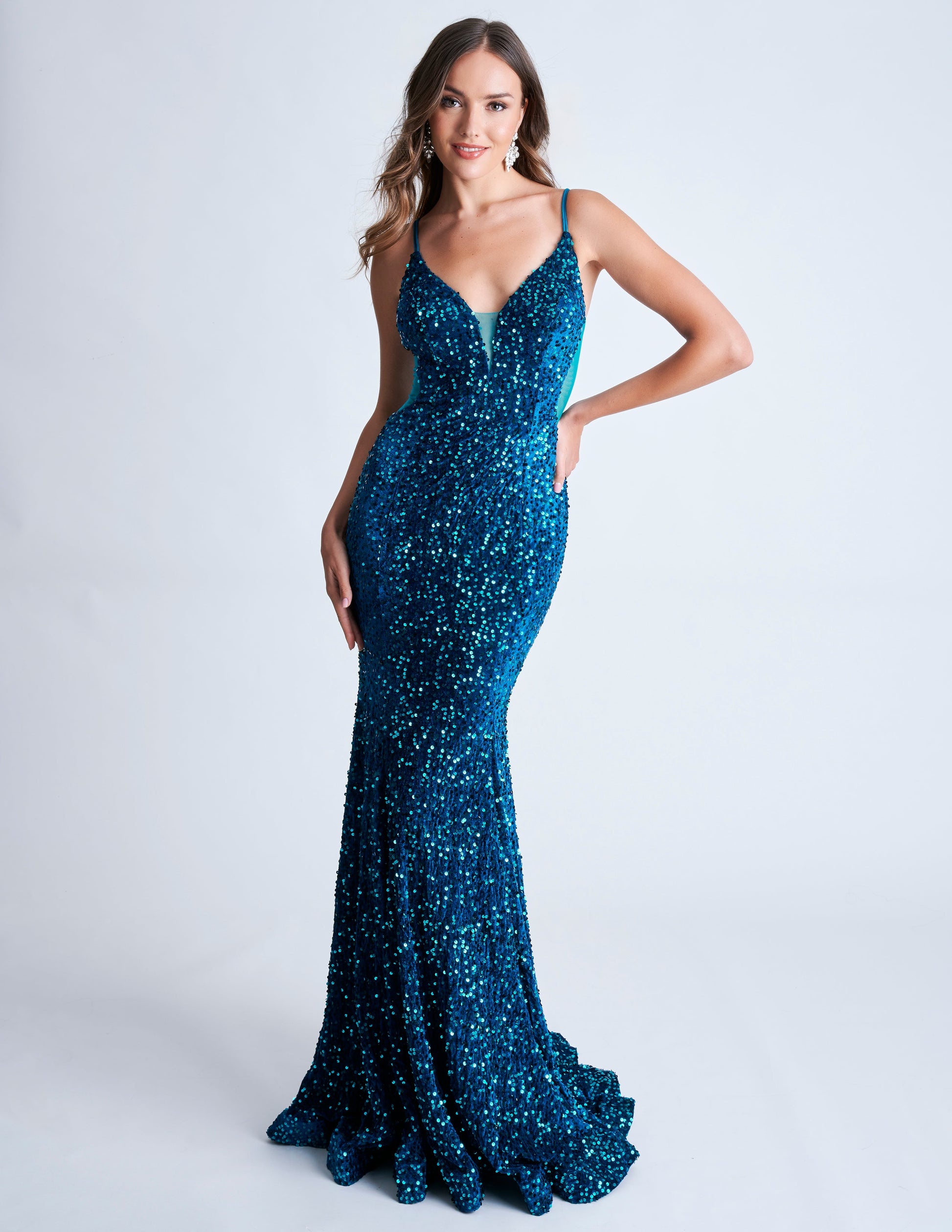 Elevate your style with the Nina Canacci 4420 Velvet Sequin Mermaid Prom Dress. Featuring a striking sheer v-neckline and stunning velvet sequin design, this formal evening gown is sure to make a statement. With its flattering mermaid silhouette, it's the perfect choice for a prom or special occasion.