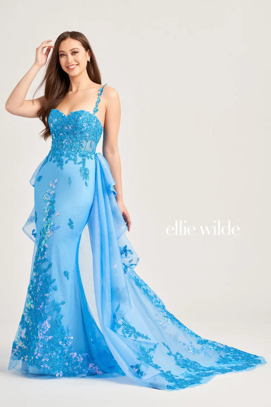 Be the center of attention in the Ellie Wilde EW35207 prom gown. Featuring a stunning lace sequin bodice with sheer corset detailing and a detachable side overskirt for added drama, this dress is perfect for pageants and prom. Turn heads and feel like a queen with this elegant and eye-catching dress.  Sizes: 00-16  Colors: Sage, Ocean Blue