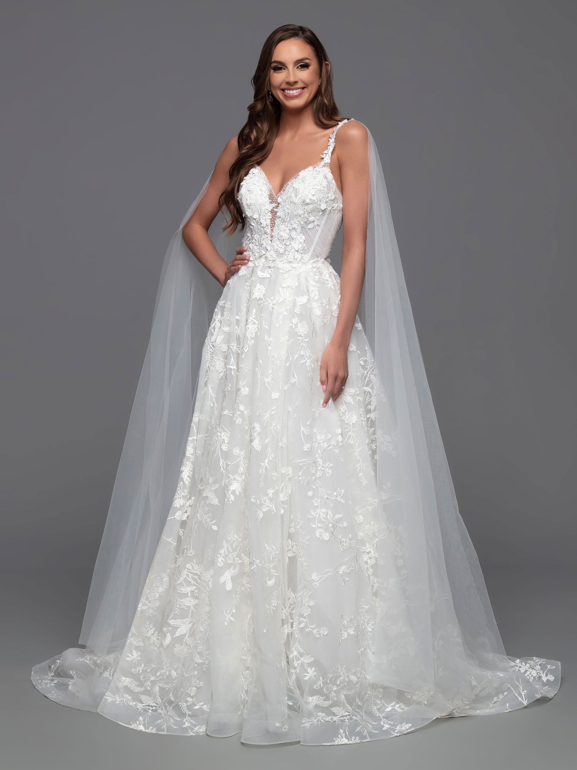 Look stunning on your special day in this Davinci Bridal 50806 A Line Lace Cape Wedding Dress. Constructed with a sheer crystal plunging neckline and 3D floral embroidery on the front and back bodice, this gown provides an exquisite look with gathered skirt and chapel train. Plus, you can customize your look and stand out in photos with the addition of the detachable veil wings.  Sizes: 2-20  Colors: Ivory