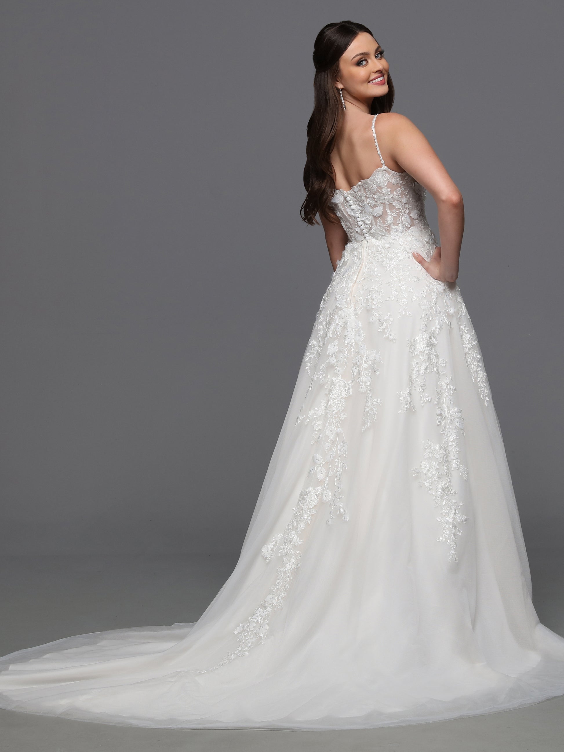 Indulge in luxury and grace with the Davinci Bridal 50834 3D Lace A Line Wedding Dress. Adorned with a detachable cape sleeves and sheer beading, this gown exudes elegance and sophistication. The 3D lace detail adds a touch of artistry, making you feel like a walking masterpiece on your special day. One of our most unique detachable styles, this wedding dress has lace gauntlets with veil wings that add drama to your portraits and your walk down the aisle.