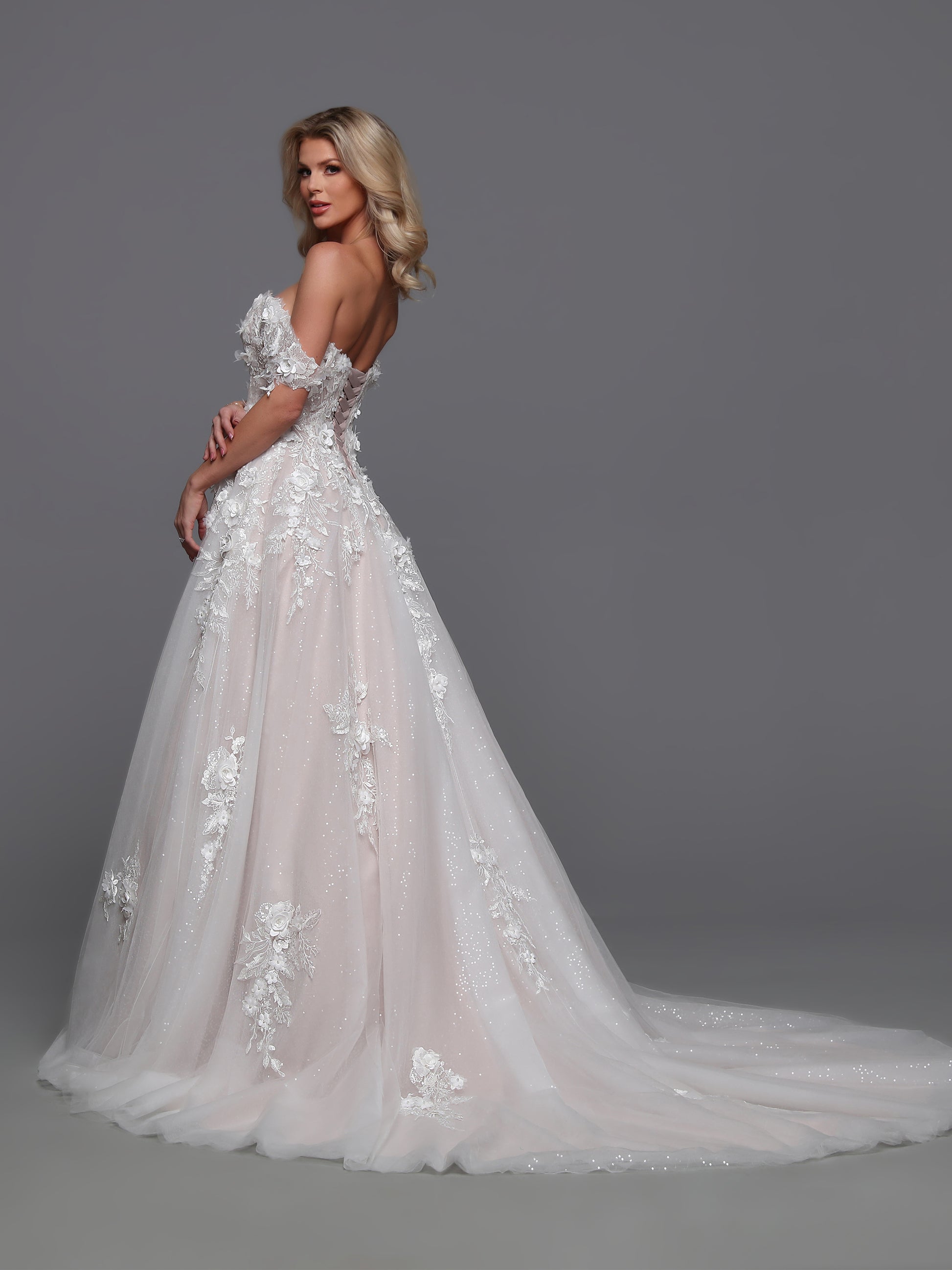 Elevate your elegance with the Davinci 50883 wedding dress. Beautifully designed with a detachable off shoulder sleeve and corset bodice, this A line lace gown exudes luxury. The sequin shimmer ballgown adds a touch of glamour, creating a one-of-a-kind bridal look that will leave a lasting impression.