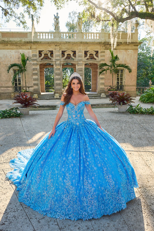 Be the belle of the ball in the Amarra 54220 Quinceanera Ball Gown. This stunning formal dress features a sheer crystal lace train and fringe, for a unique and eye-catching look. The off the shoulder design adds a touch of elegance and the perfect amount of skin. Stand out in style. Unleash your inner princess with our enchanting lace ball gown! Crafted with a dreamy lace fabric adorned with detailed floral pattern