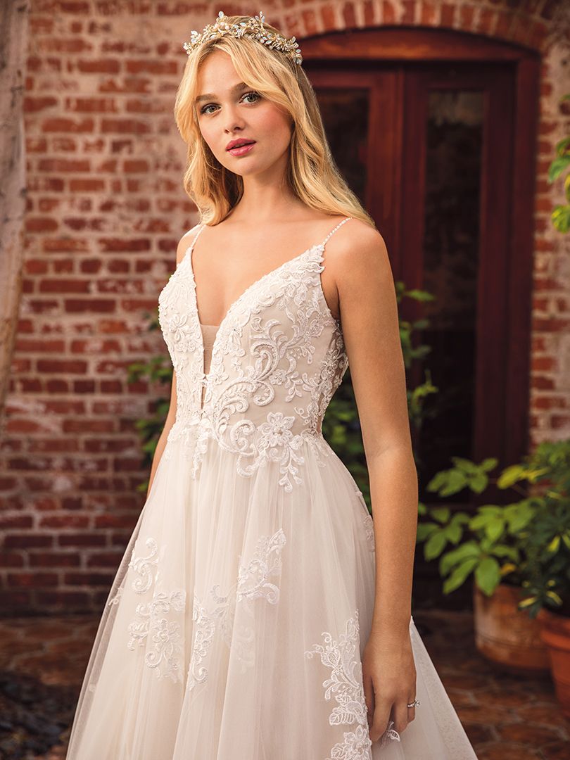 Casablanca Beloved STYLE BL286 DELILAH Other-worldly grace surrounds Delilah, swimming in sateen satin and tulle. Lace appliques cover the bodice and cascade down the flowing skirt of this bohemian wedding gown from Beloved by Casablanca Bridal. Spaghetti straps and a plunging neckline add a seductive touch, transitioning into an alluring illusion lace back. Subtle silver beading catches the light, while a matching veil finishes off this modern boho gown with a glimmer!