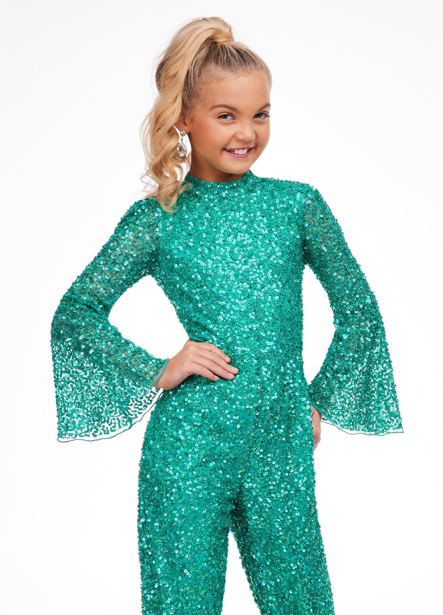 Ashley Lauren Kids 8091 Long Bell Sleeve Girls Sequin Jumpsuit Fun Fashion Wear Make a statement in the sequin jumpsuit featuring a high neckline and bell sleeves. The open back completes the look! High Neckline Open Back Bell Sleeves Jumpsuit Available Sizes: 2-14 Available Colors: Jade, Iridescent Purple, Bright Pink