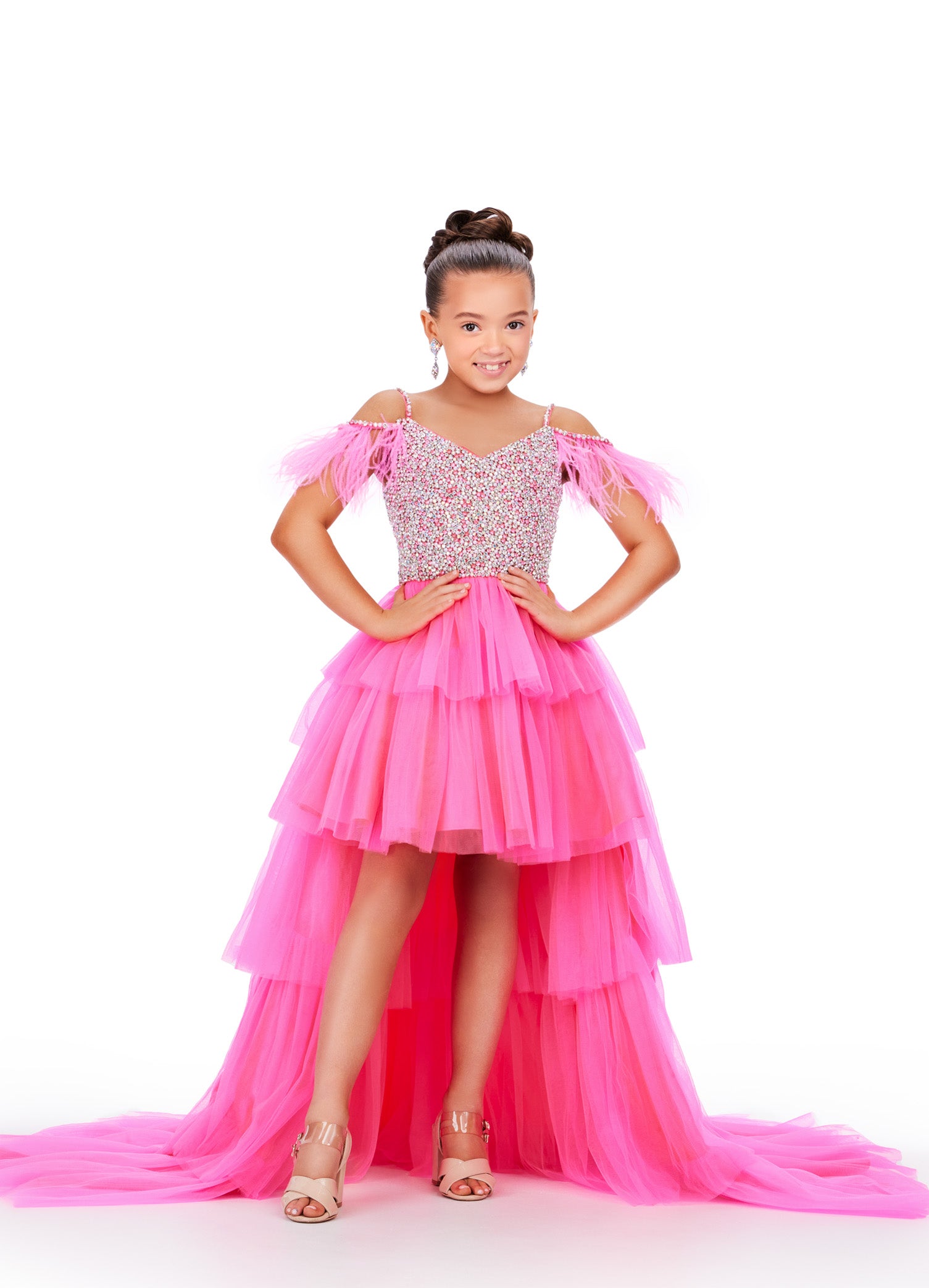 This Ashley Lauren Kids 8259 dress features layered tulle, a high low style, and an off the shoulder design with delicate feather accents. Perfect for pageants, your little girl will look stunning and feel confident in this unique and elegant dress. This fun & flirty kids tulle tiered high low features off the shoulder feather straps and a crystal encrusted bodice