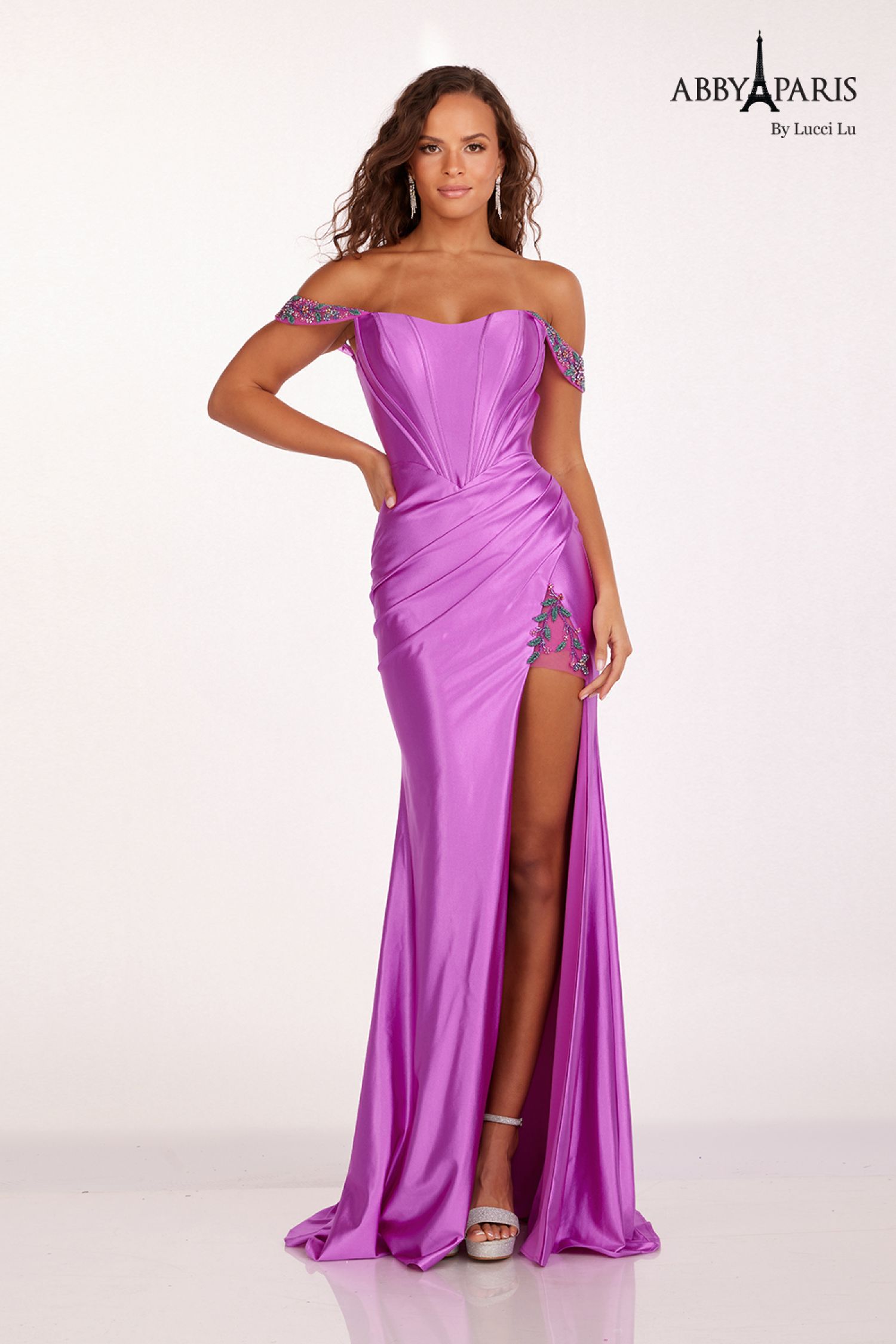 Discover the perfect blend of elegance and style with our Abby Paris 90206 Prom Dress. Crafted with luxurious satin and intricate beading, this dress is designed to accentuate your figure and make you stand out at any formal event. The stunning off-the-shoulder neckline and corset back add a touch of sophistication, while the maxi slit adds a modern twist. Embrace your inner fashion icon with this statement piece.  Sizes: 0-16  Colors: Emerald, Red, Violet