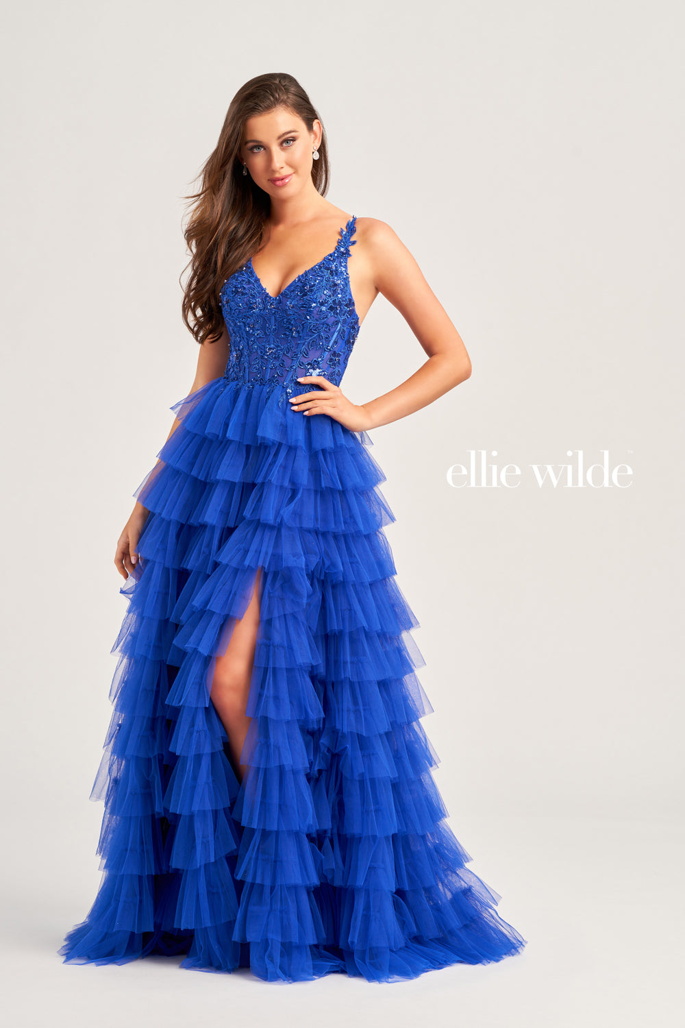 This Ellie Wilde EW35059 prom dress exudes elegance and glamour. The long tulle layers, A-line silhouette, and lace Sequin corset enhance your natural curves, while the maxi slit and sequin details add a touch of sparkle. Perfect for prom or any formal event, this dress is sure to make a statement.  Sizes: 00-20  Colors: ﻿BLACK, MAGENTA, ROYAL BLUE, BARBIE PINK