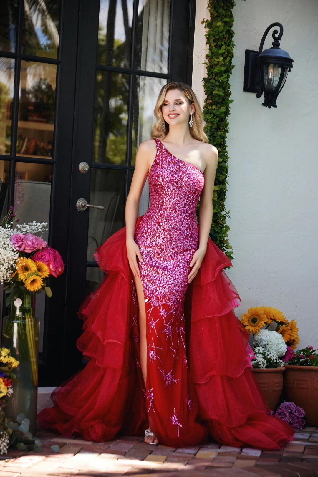 Step into the spotlight with the Ava Presley 29236, a dazzling gown that combines glamour with a touch of drama. This one-shoulder dress features a fully sequined bodice that cascades into a voluminous layered skirt with a high slit, adding movement and flair to your look. Perfect for any formal event where you want to make a bold statement, this gown is designed to leave a lasting impression.