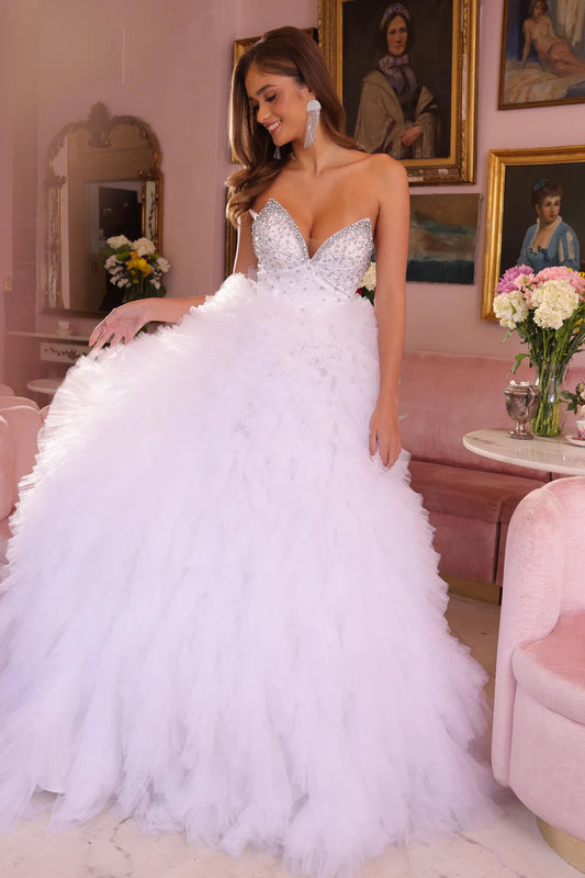 This Ava Presley gown, style 29528, embodies a fairytale elegance with its voluminous, layered tulle skirt and sparkling bodice. The plunging neckline adds a hint of allure while the glittering embellishments across the bodice bring a dazzling touch to the design. The dramatic skirt creates a princess-like silhouette, making it ideal for a formal occasion or even a modern wedding. Amazing Prom &amp; Pageant Dress!