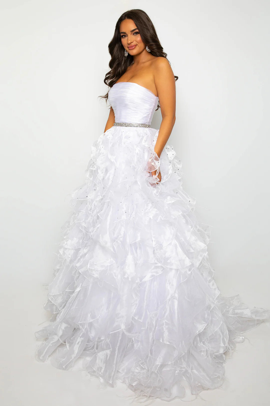 Elevate your formal attire with the Ava Presley 39555 Ballgown. This luxurious dress boasts a long feather ruffle and a strapless design, exuding elegance and style. Perfect for prom or pageants, this exclusive dress will make you feel like a true fashion icon. Float down the runway in this ethereal strapless ball gown, featuring a ruched bodice and cascading ruffle skirt that brings volume and drama. The cinched waist, adorned with a sparkling belt, adds a touch of glamour to this stunning look. Perfect fo