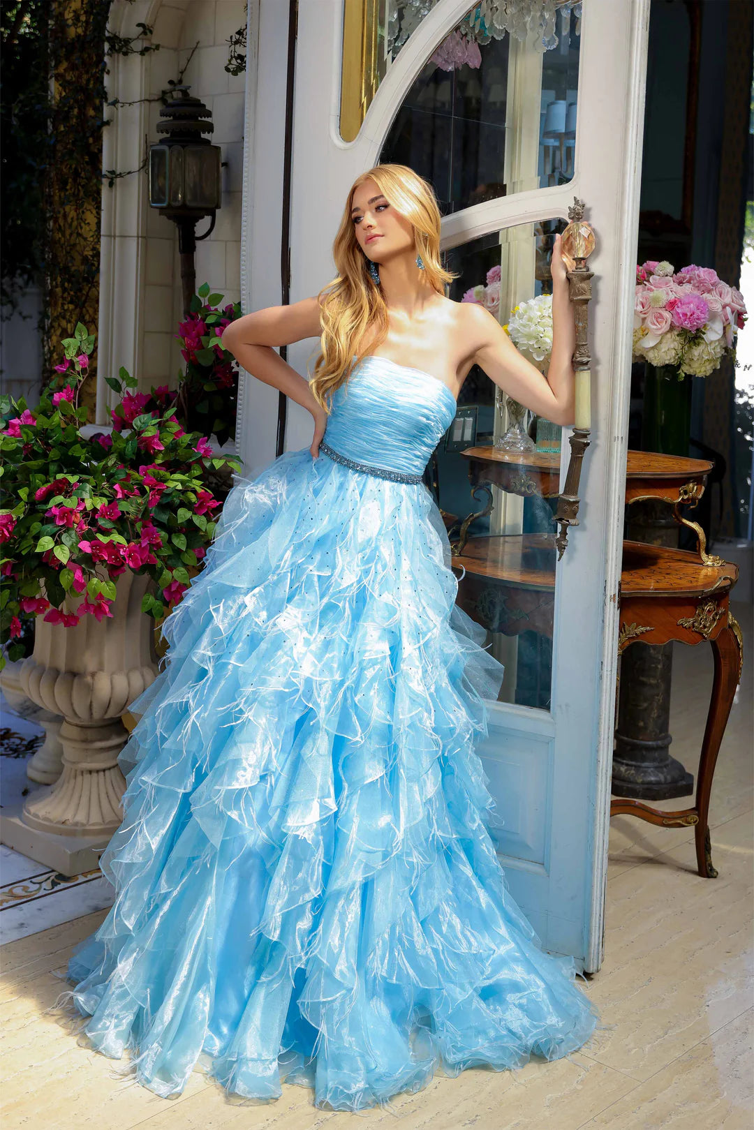 Elevate your formal attire with the Ava Presley 39555 Ballgown. This luxurious dress boasts a long feather ruffle and a strapless design, exuding elegance and style. Perfect for prom or pageants, this exclusive dress will make you feel like a true fashion icon. Float down the runway in this ethereal strapless ball gown, featuring a ruched bodice and cascading ruffle skirt that brings volume and drama. The cinched waist, adorned with a sparkling belt, adds a touch of glamour to this stunning look. Perfect fo