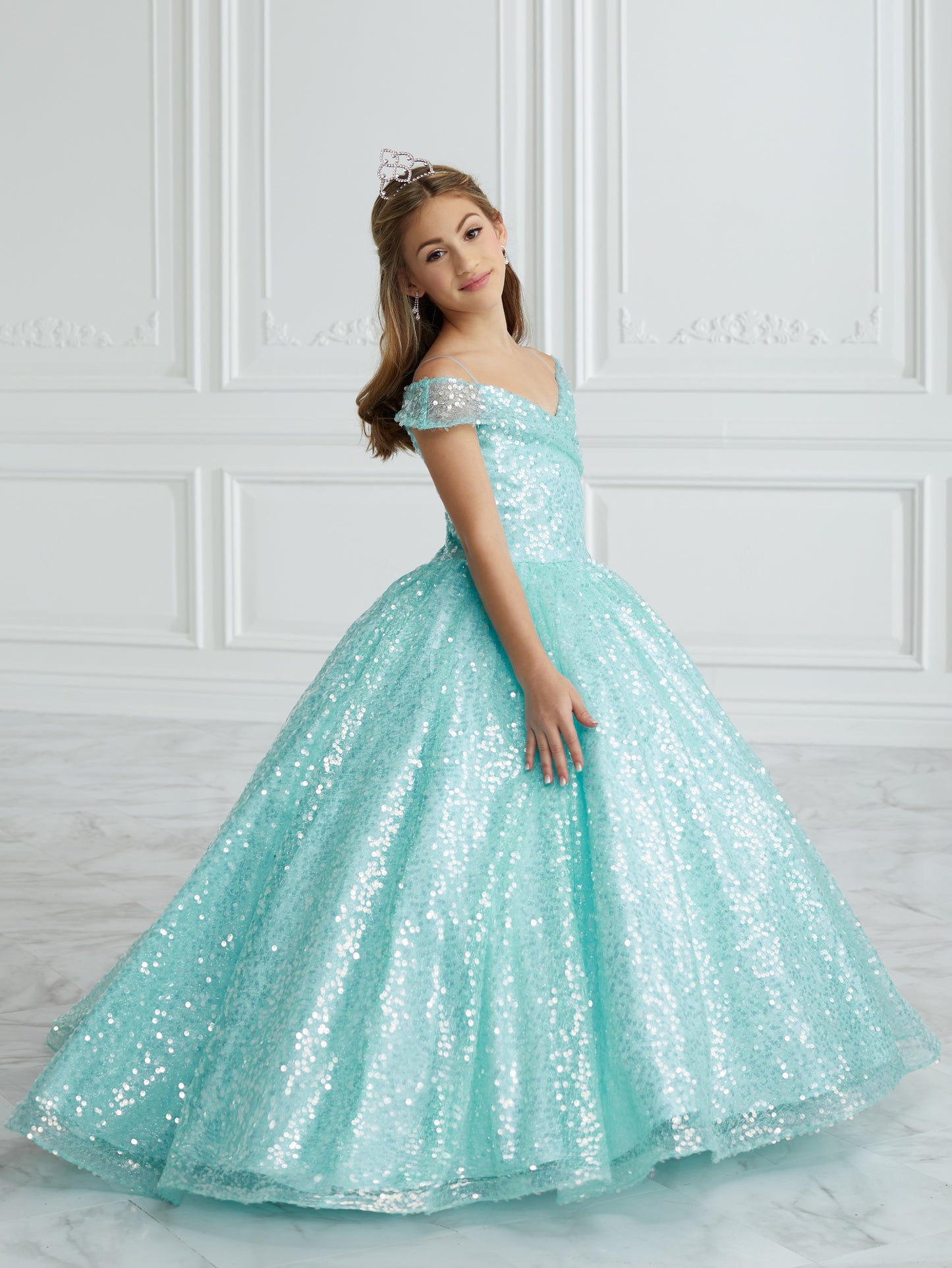 This stunning Tiffany Princess 13679 pageant dress features a dazzling sequin design, off the shoulder neckline, and a full ball gown silhouette, making your little one feel like royalty. Perfect for formal events and pageants, this dress is both elegant and eye-catching