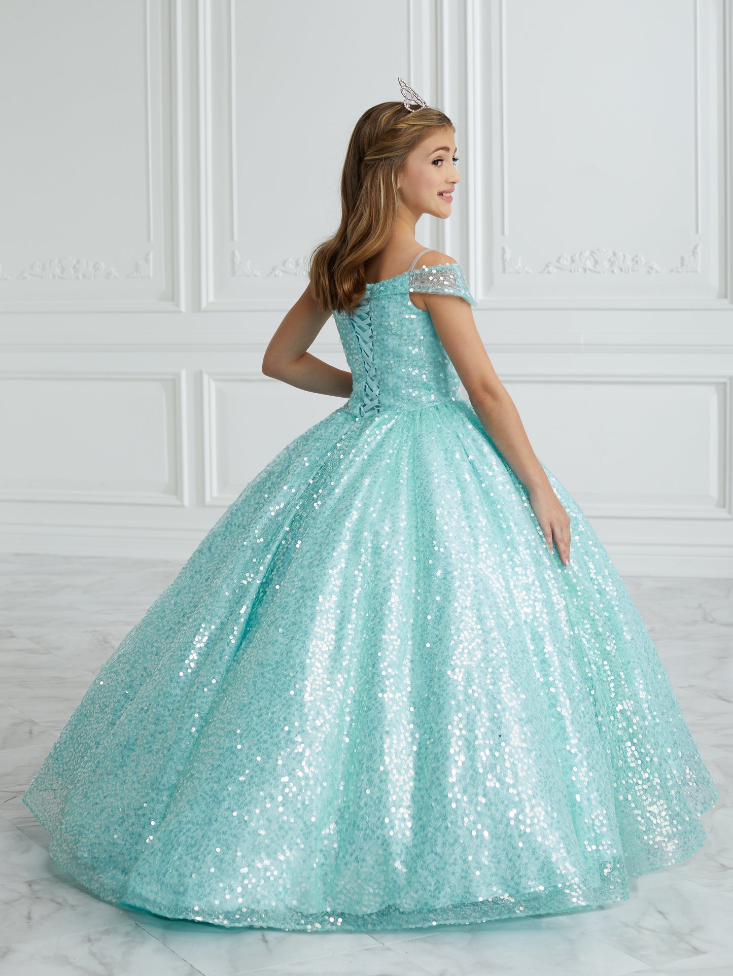 This stunning Tiffany Princess 13679 pageant dress features a dazzling sequin design, off the shoulder neckline, and a full ball gown silhouette, making your little one feel like royalty. Perfect for formal events and pageants, this dress is both elegant and eye-catching