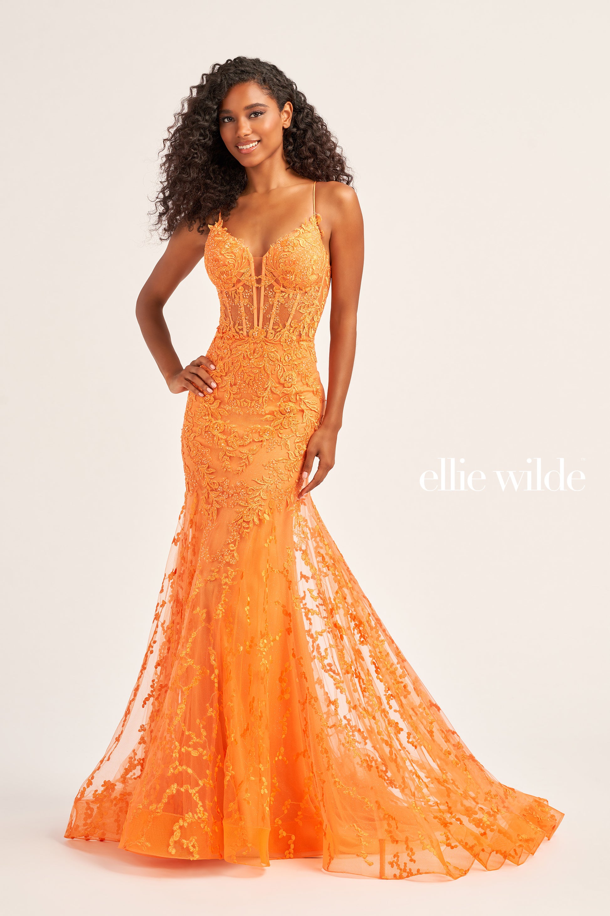 The Ellie Wilde EW35010 dress features a plunging sweetheart neckline, corset bodice, and lace-up back to flatter your figure while adding a touch of sophistication. Crafted from shimmering tulle, glitter tulle, lace, and embellished with stone accents, this long trumpet silhouette is perfect for making a statement on your special day. Plus, this dress is designed with a natural waistline for comfort.  COLOR: BLACK, ORANGE, LIGHT YELLOW, MAGENTA, EMERALD, ROYAL BLUE, SAGE, STRAWBERRY SIZE: 00 - 20