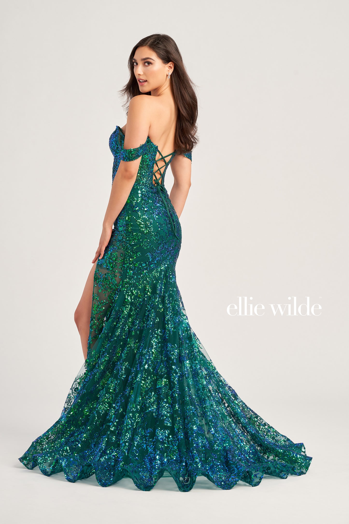 The Ellie Wilde EW35014 Sheer Sequin Slit off the shoulder Prom Dress is a formal dress with a corset closure for a perfect fit. It features detachable draped off shoulder straps, a high slit for an alluring look, lace-up back, and separate spaghetti straps for extra support. Deep plunging V Neckline.  COLOR: MIDNIGHT, LIGHT BLUE, EMERALD, HOT PINK SIZE: 00 - 16