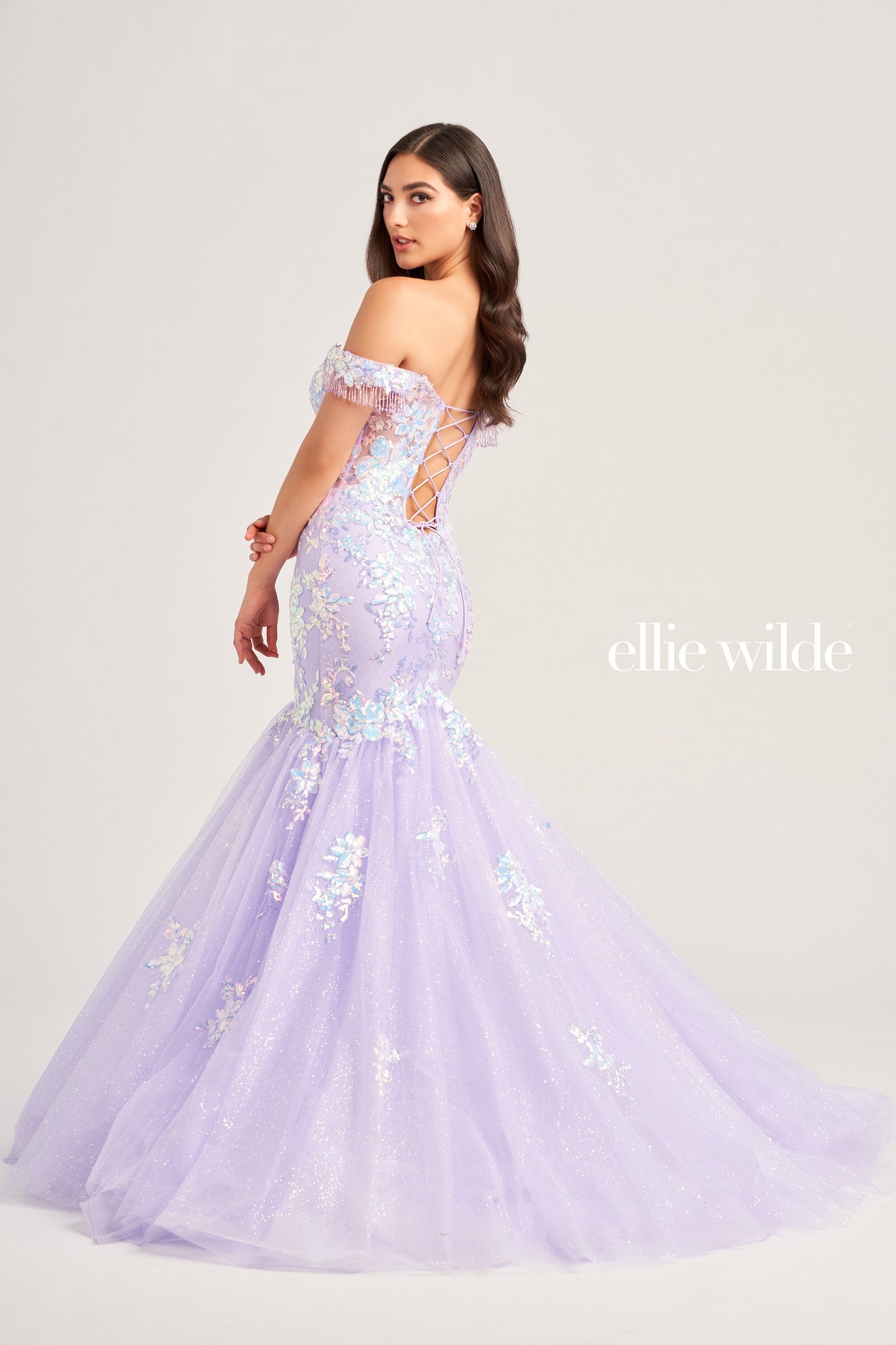 This stunning Ellie Wilde EW35219 Long Shimmer Sequin Mermaid Dress will make you stand out at any special occasion. Crafted with glitter tulle fabric and sequin appliqué, the eye-catching off the shoulder fringe adds a unique touch to the plunging sweetheart neckline and corset bodice. The luxurious lace-up back and natural waistline ensures the perfect fit.  COLOR: OCEAN BLUE, DARK PURPLE, LILAC SIZE: 00 - 16