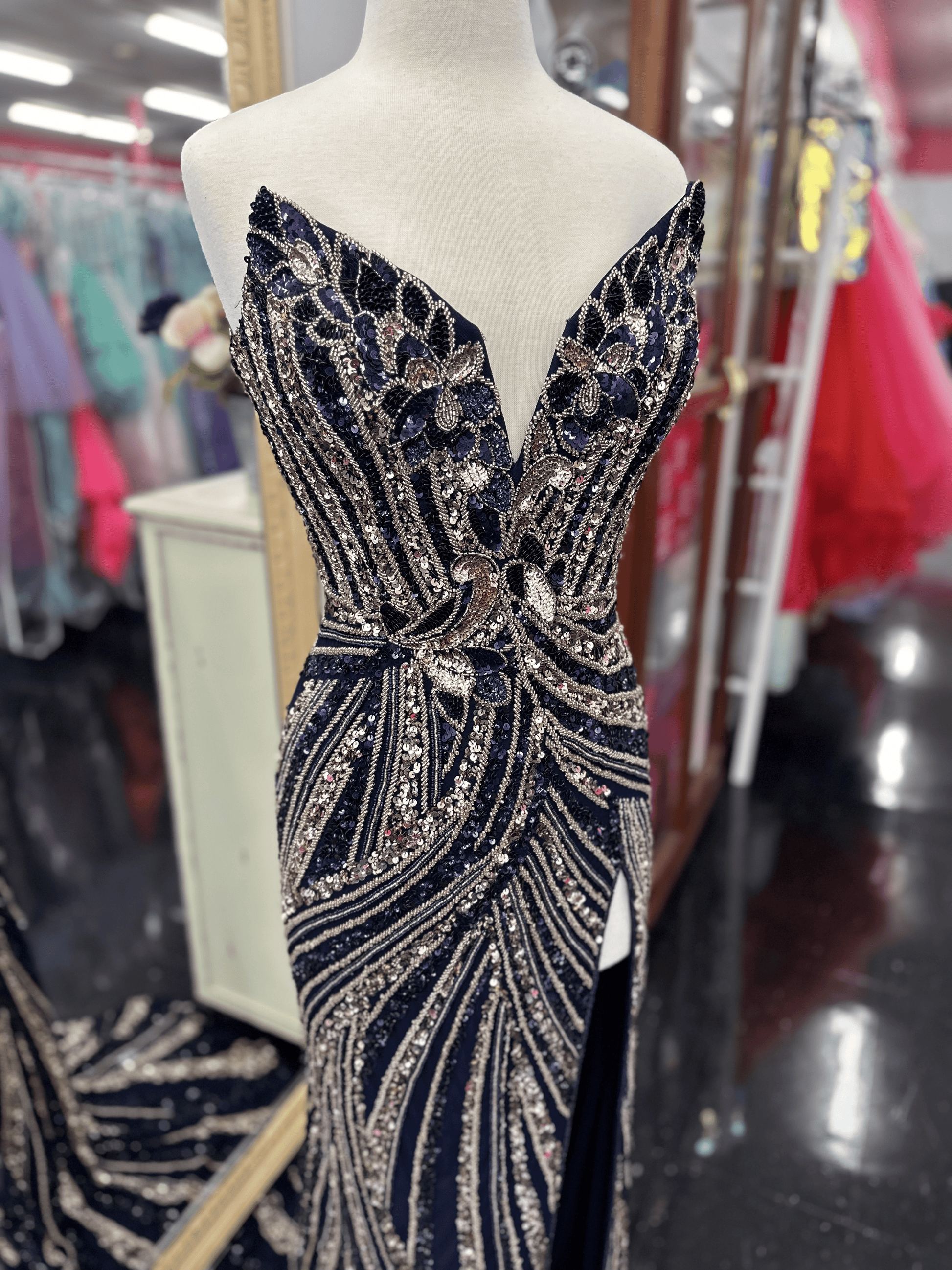 Ashley Lauren 11236 Long Fitted V Neck Slit Beaded Sequin Prom Dress Pageant Gown This strapless gown is sure to turn heads. The sweetheart neckline is complete with a modern floral sequin motif that continues down the bustier and skirt. The skirt is complete with a left leg slit.