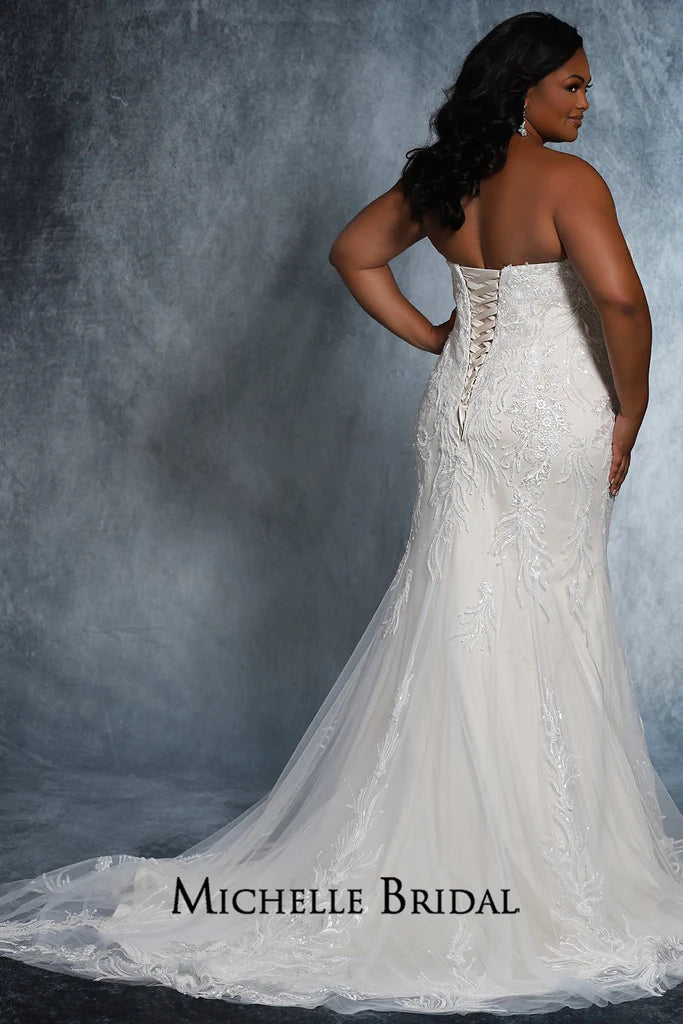 The Michelle Bridal for Sydney's Closet MB2117 is a stunning plus-size bridal gown featuring a strapless sweetheart neckline, lace-up back, and fitted silhouette adorned with floral appliques and pearls. Made with sequins for added sparkle, this striking gown will be sure to make any bride's special daydream come true.