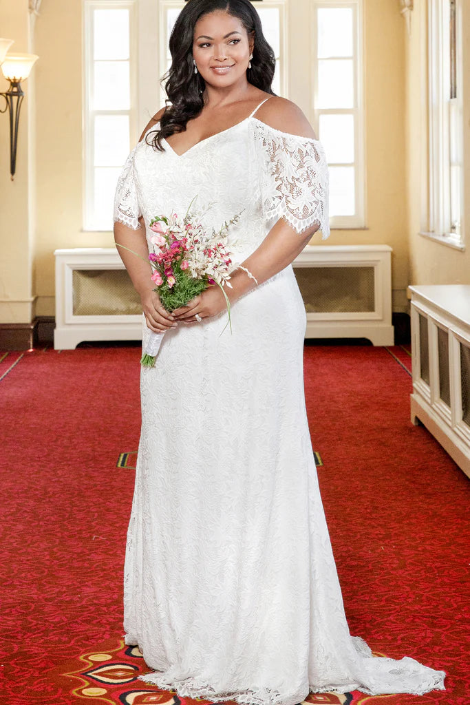 Michelle Bridal For Sydney's Closet MB2306 Slim Sheath Boho Lace With Eyelash Trim Bridal Tulle V-Neck Plus Size "Kahlo" Bridal Gown Fall in love with the romantic lace details of this Michelle Bridal For Sydney's Closet MB2306 plus size bridal gown. With its delicate eyelash trim, slim sheath silhouette and v-neck neckline, you'll feel beautiful and confident on your special day. Crafted from lightweight, breathable tulle fabric for a comfortable fit all night long.