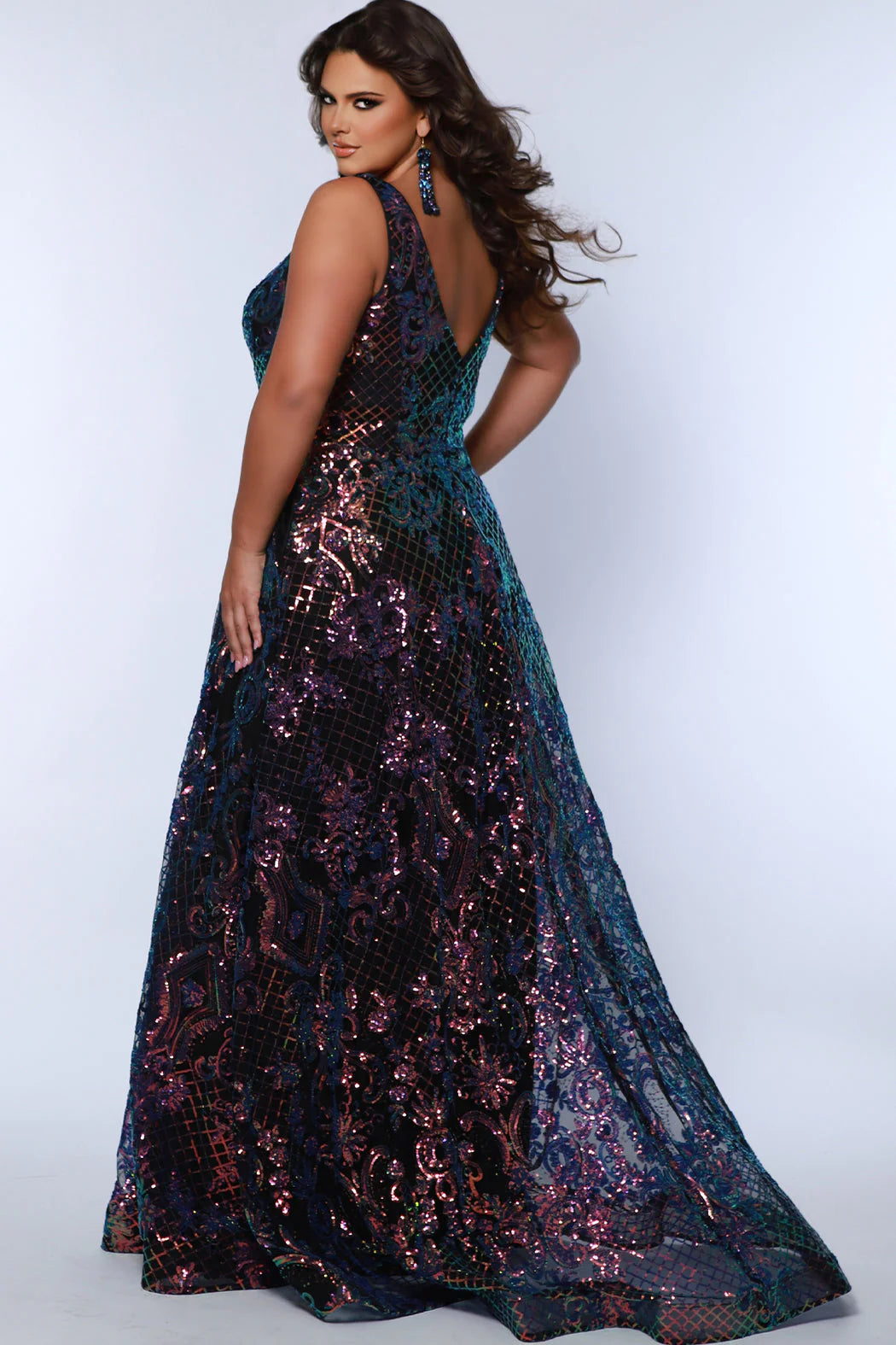 This elegant, plus size Sydneys Closet SC7367 Long Prom Dress features a V-neckline, sequins, pockets, and a long train--all crafted from a luxurious fabric for a stylish and comfortable look. Its timeless design makes it perfect for formal occasions. Make a trendy fashion statement at Prom or any formal when you wear this eye-catching plus size evening dress. 