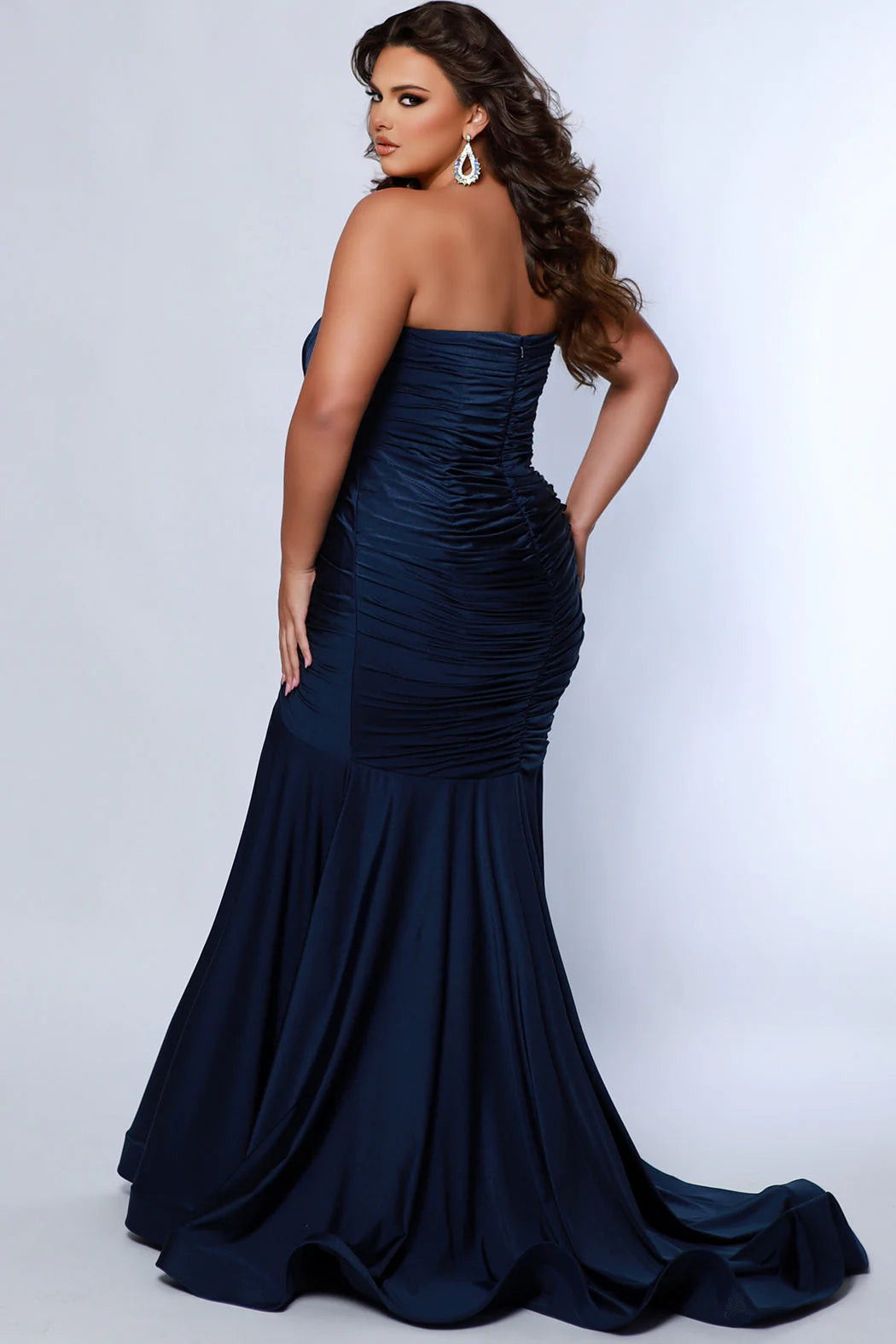 Make a statement in this luxurious Sydneys Closet SC7374 prom dress. This long, fitted gown is crafted in a mermaid silhouette, with a strapless neckline, ruching from the waistline to the floor, and a statement train. Perfect for plus size formal occasions. Look glamorous at Prom 2024 or any dressy event when you wear our Simply Ravishing plus size formal Mermaid gown. 