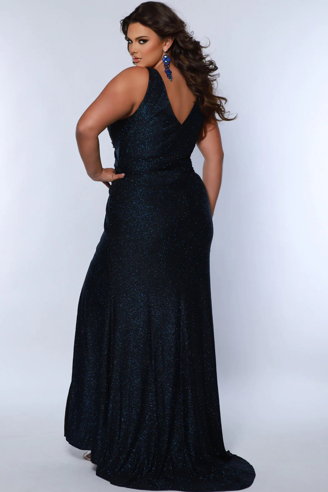 Sydneys Closet SC7376 offers a fitted plus size formal gown featuring a flattering V-neck, maxi slit skirt, and train detail for an unforgettable look. Perfect for prom or pageants. Look effortlessly elegant as a formal wedding guest or for any fancy evening that awaits you in the Late Night Sparkle plus size simple maxi dress. 