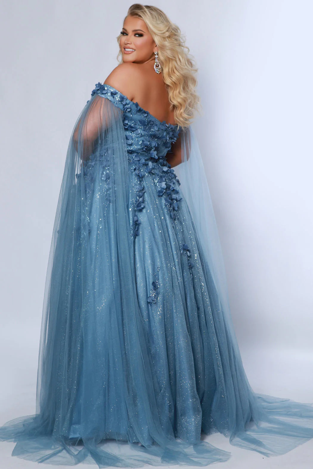 This glamorous Sydneys Closets SC7379 prom dress features an off-shoulder, sweetheart neckline and a fitted silhouette adorned with 3D floral details. The elegant design is perfect for a formal occasion such as a prom, pageant, or wedding. Plus size options are available for an ideal fit. Look and feel  like royalty at Prom 2024 or any formal ball when you opt to be lady who wears our "Dream On" gown.