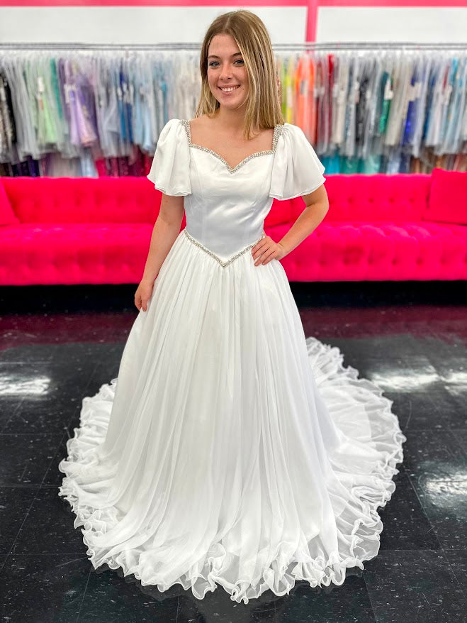 Make your little girl feel like a princess in the Samantha Blake 1126 Girls Pageant Dress. Featuring Chiffon ruffle cap sleeves and a satin bodice, this formal gown exudes elegance and charm. With an A-line silhouette, it flatters any figure and is perfect for pageants or special occasions.