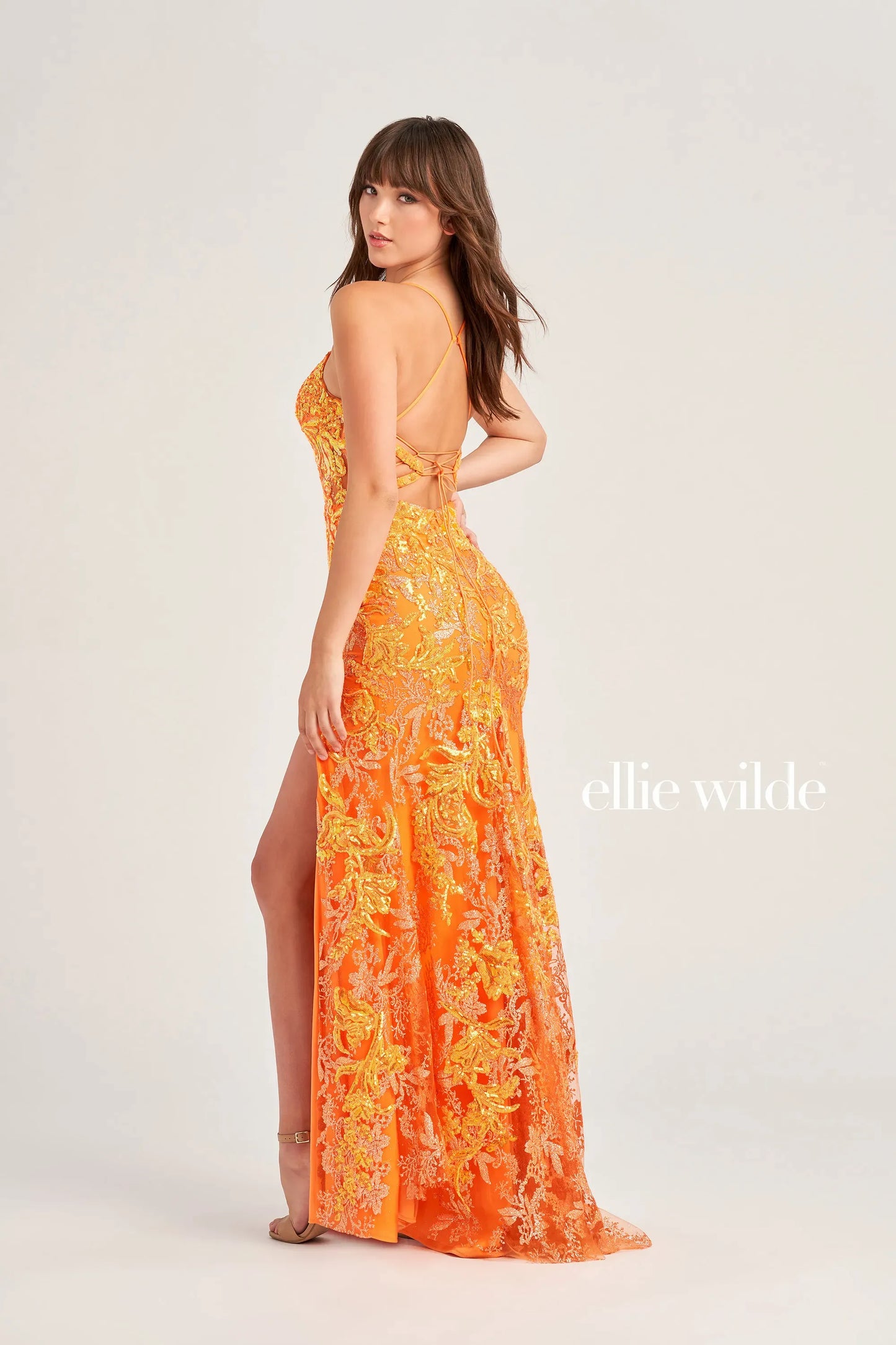 The Ellie Wilde EW35060 is a stunning long prom dress featuring a sheer corset top with intricate sequin designs. The backless design adds a touch of elegance, while the high slit allows for easy movement. Step out in style and make a statement with this formal gown.  Sizes: 00-20  Colors: ORANGE, LIGHT BLUE, HOT PINK