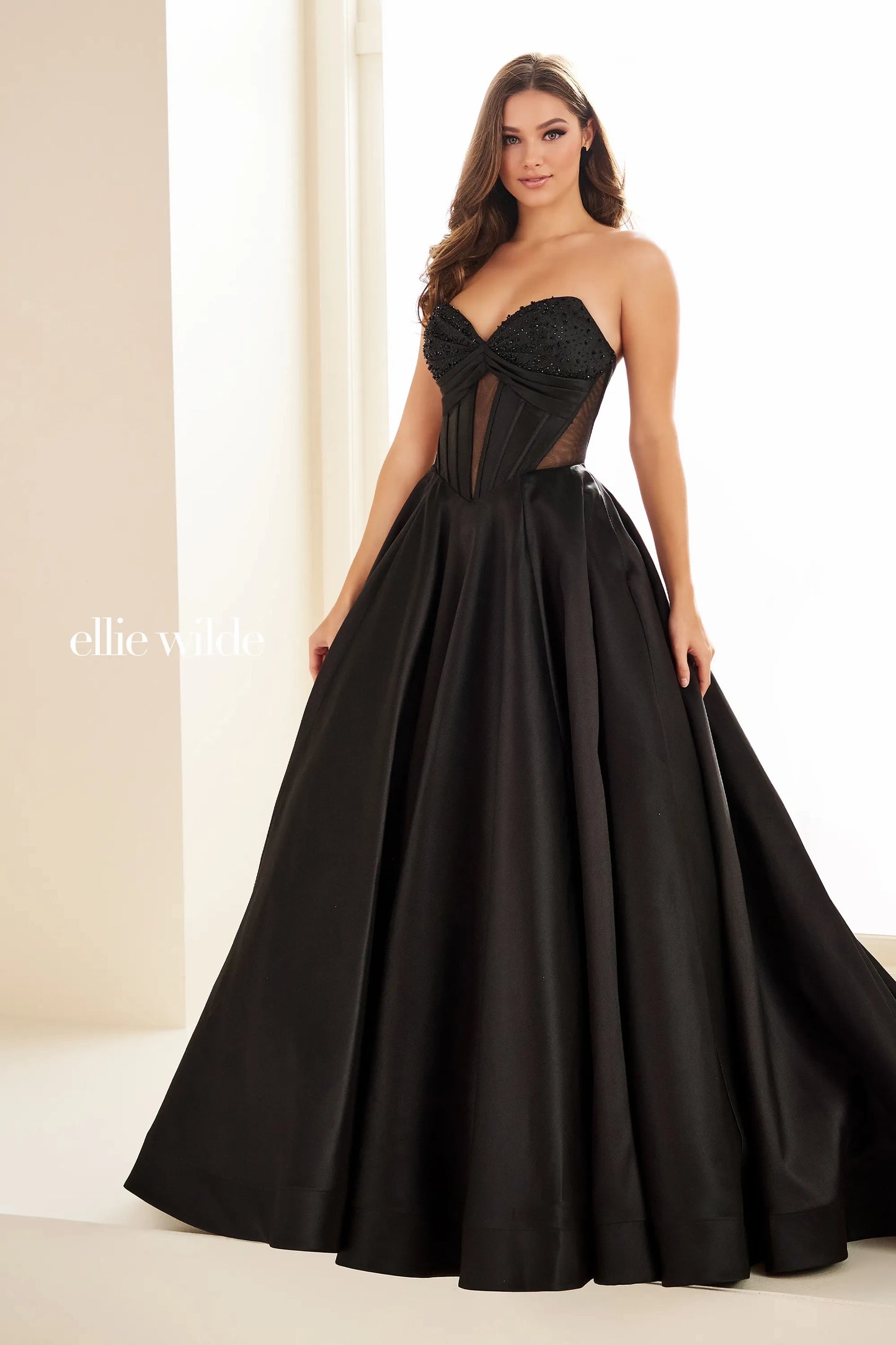 This Ellie Wilde EW36025 prom dress features a stunning A-line silhouette with sheer ballgown detailing and a corset back for a perfect fit. The dress also includes convenient pockets and cut-out design, making it both fashionable and functional for any pageant or formal event.