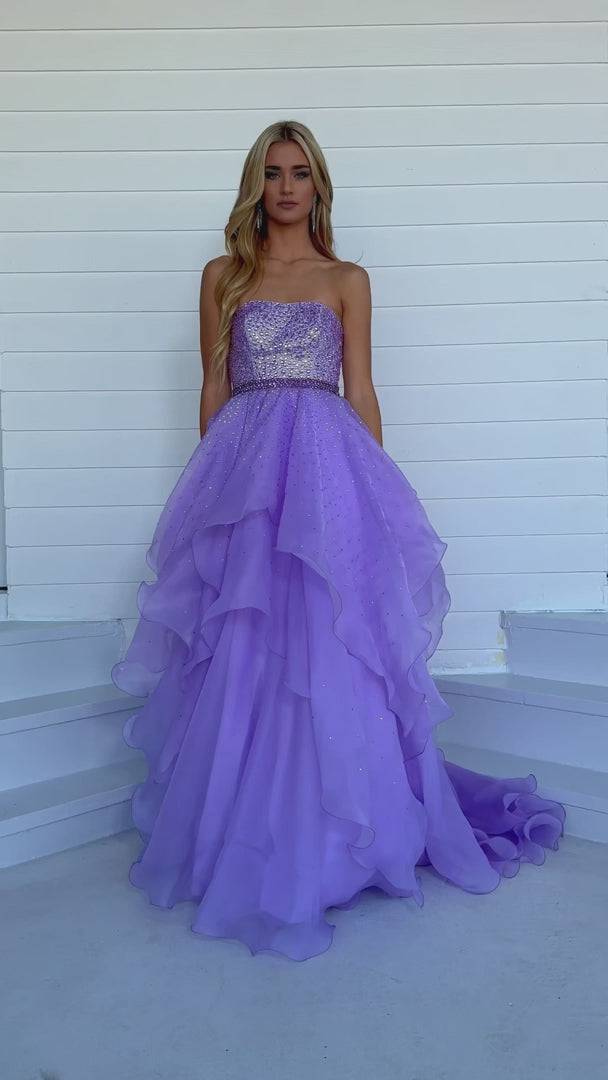 Add a touch of elegance to any formal event with the Ava Presley 39561 Long Prom Dress. The beaded bodice and halter top provide a dazzling look, while the crystal belt-line and layered ruffles add texture and movement. Perfect for prom, pageants, or any special occasion.