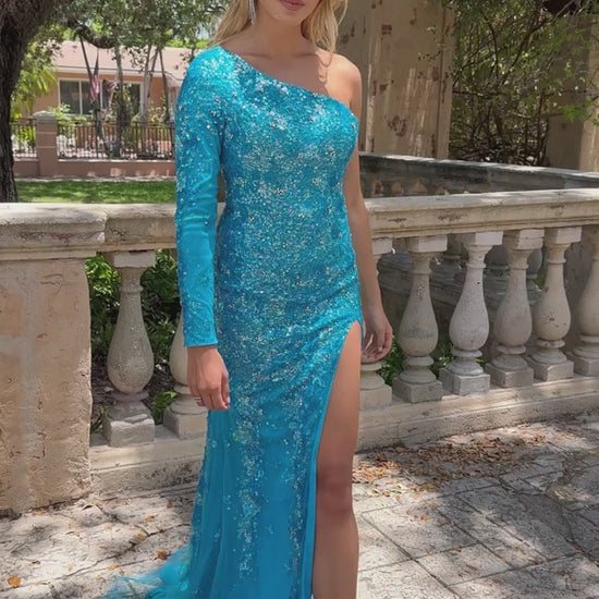 This stunning Ava Presley 28578 long prom dress features a one shoulder design with an intricate sequin pattern. The high slit and cape sleeve add a touch of elegance to this formal gown, making it perfect for any pageant or special occasion. Make a statement and stand out in style with Ava Presley.