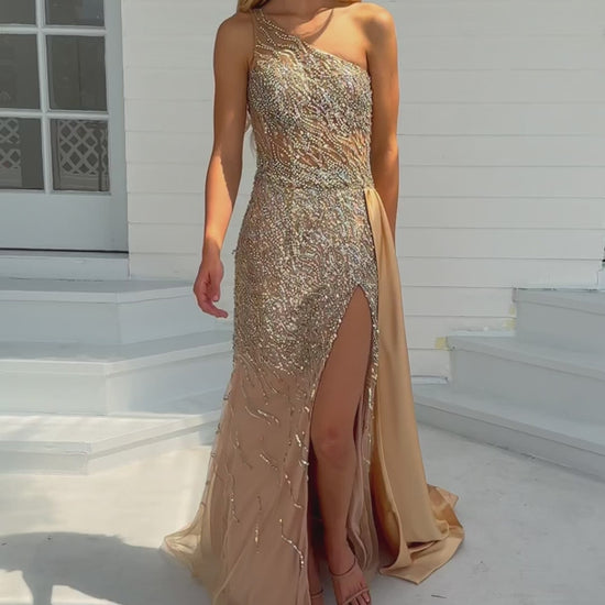 Expertly crafted for the ultimate prom or pageant look, the Ava Presley 28589 Long Prom Dress features a stunning one shoulder design, intricate beaded crystal detailing, and a sheer bodice for a touch of elegance. With a sleek side satin skirt and a high slit, this formal gown exudes sophistication and style.